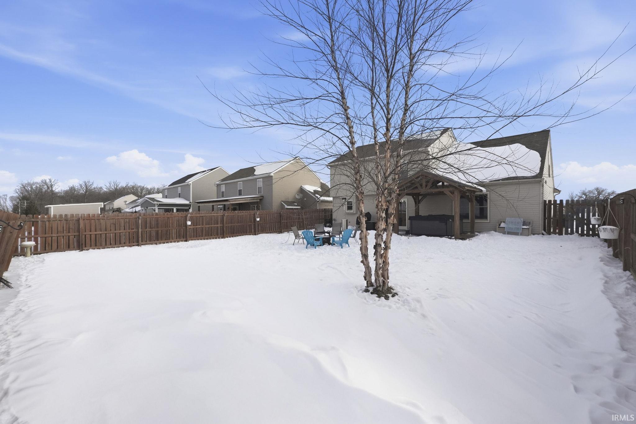 Snowy yard with a fenced backyard and a residential view