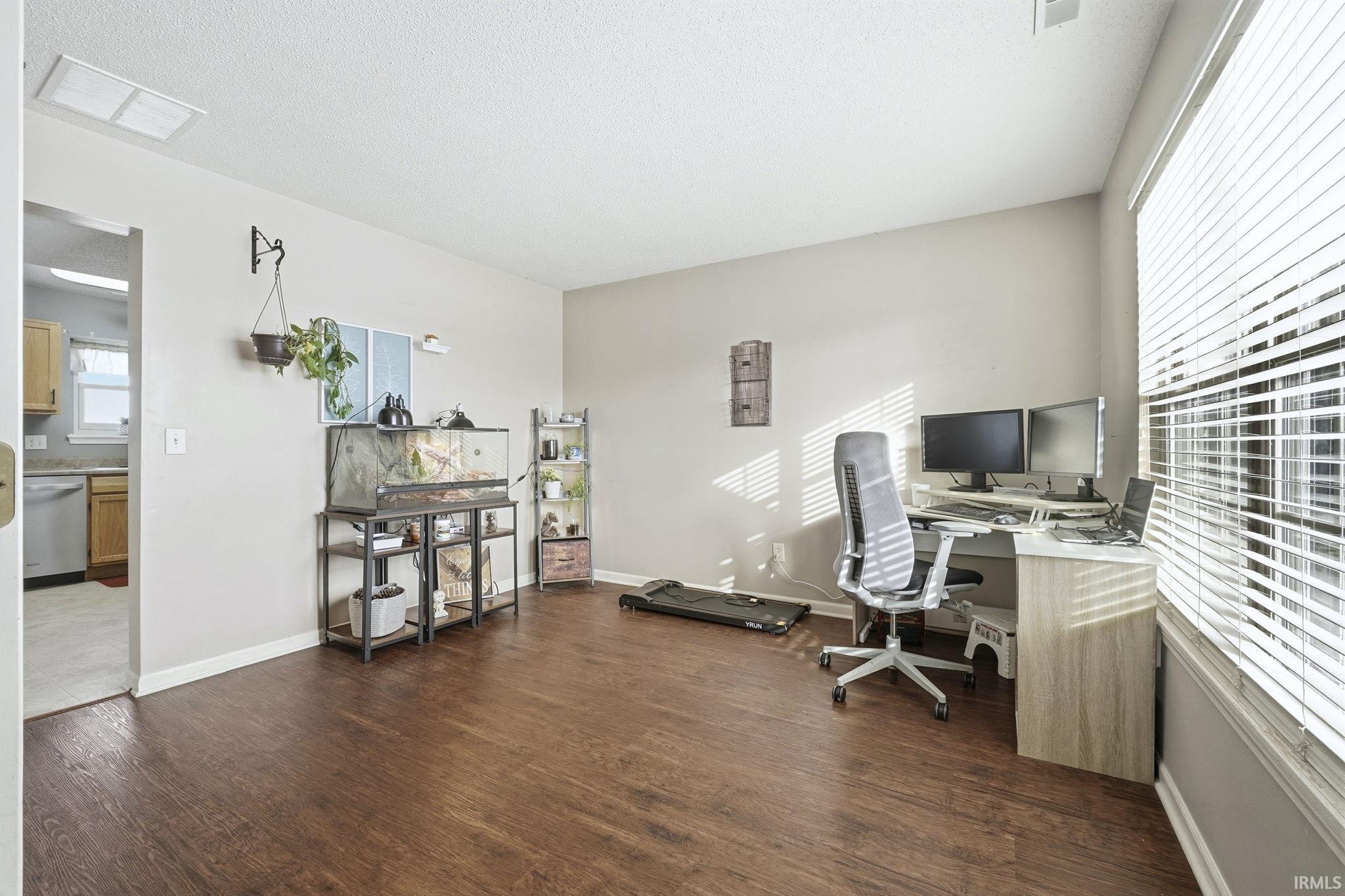 Home office with dark wood finished floors and baseboards