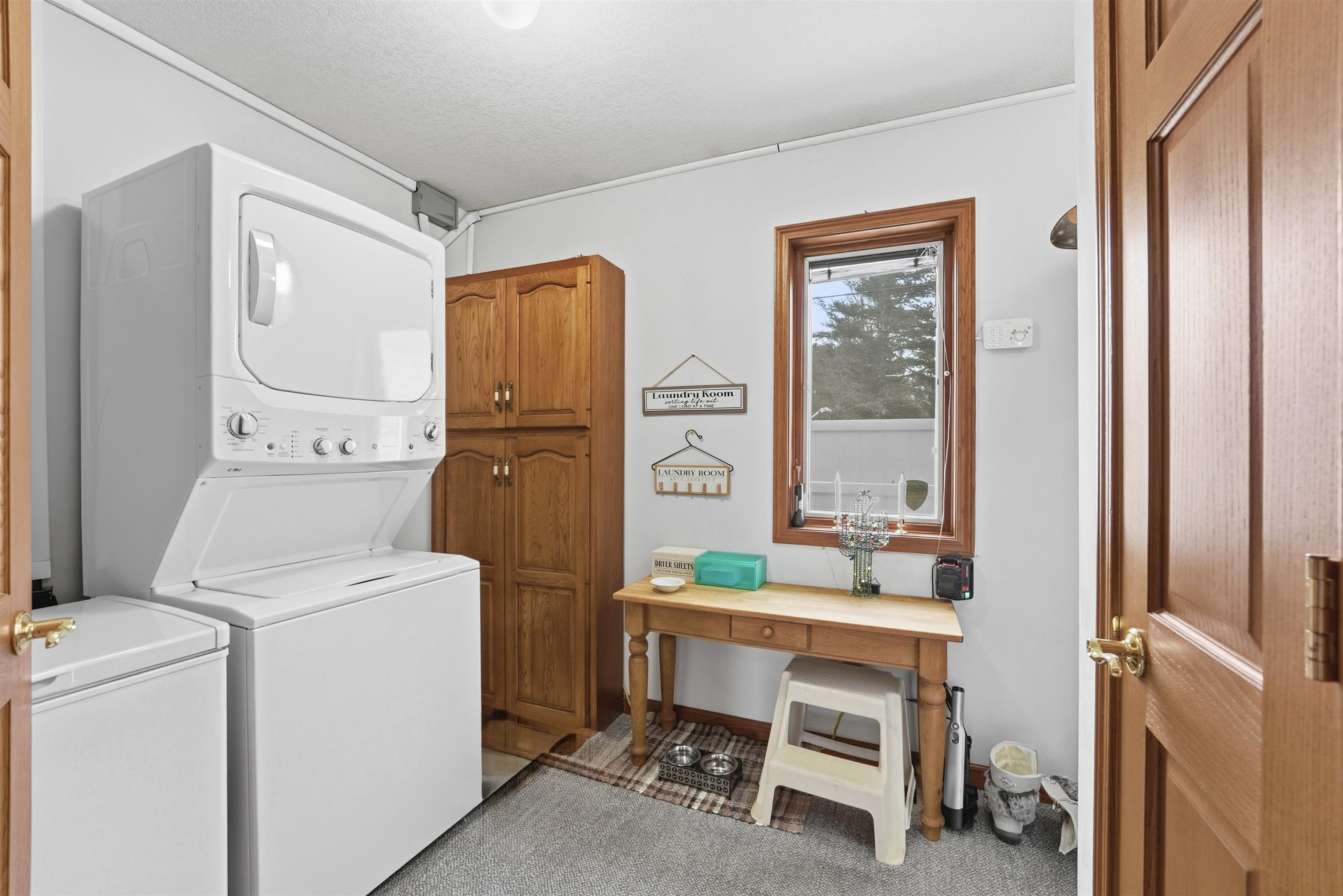 Laundry area with stacked washing machine and dryer and cabinet space