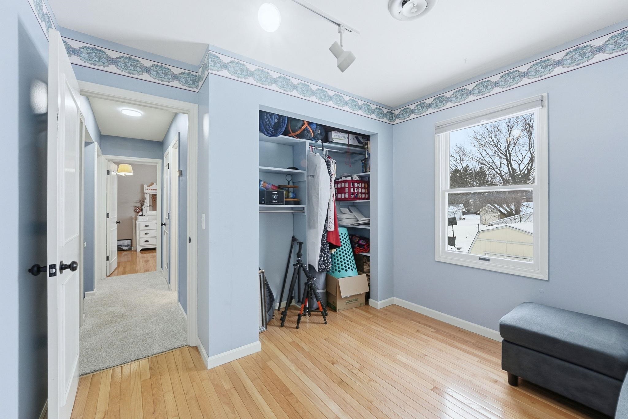 Bedroom featuring light wood-type flooring, a closet, and track lighting