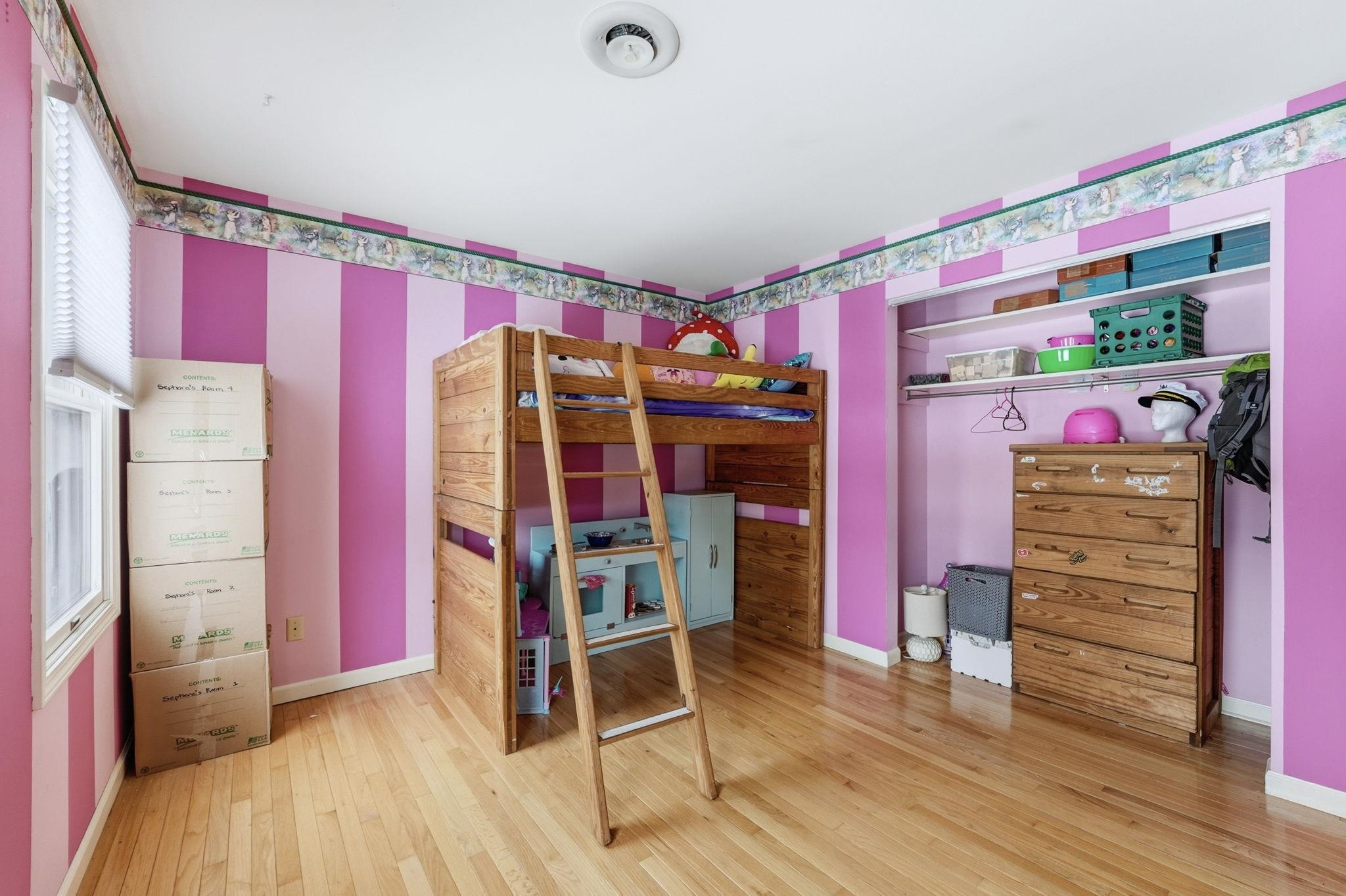 Bedroom with hardwood / wood-style flooring and baseboards