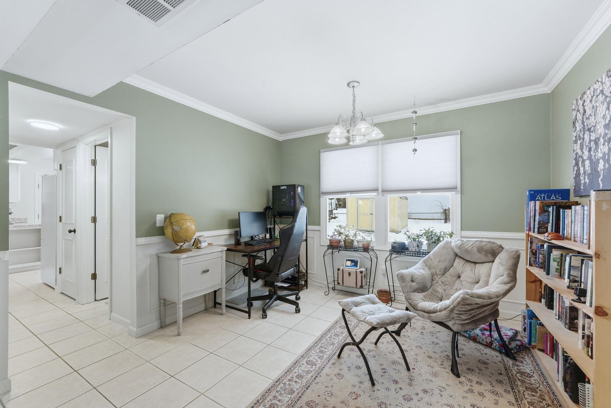 Office with wainscoting, light tile patterned floors, ornamental molding, and hanging lights