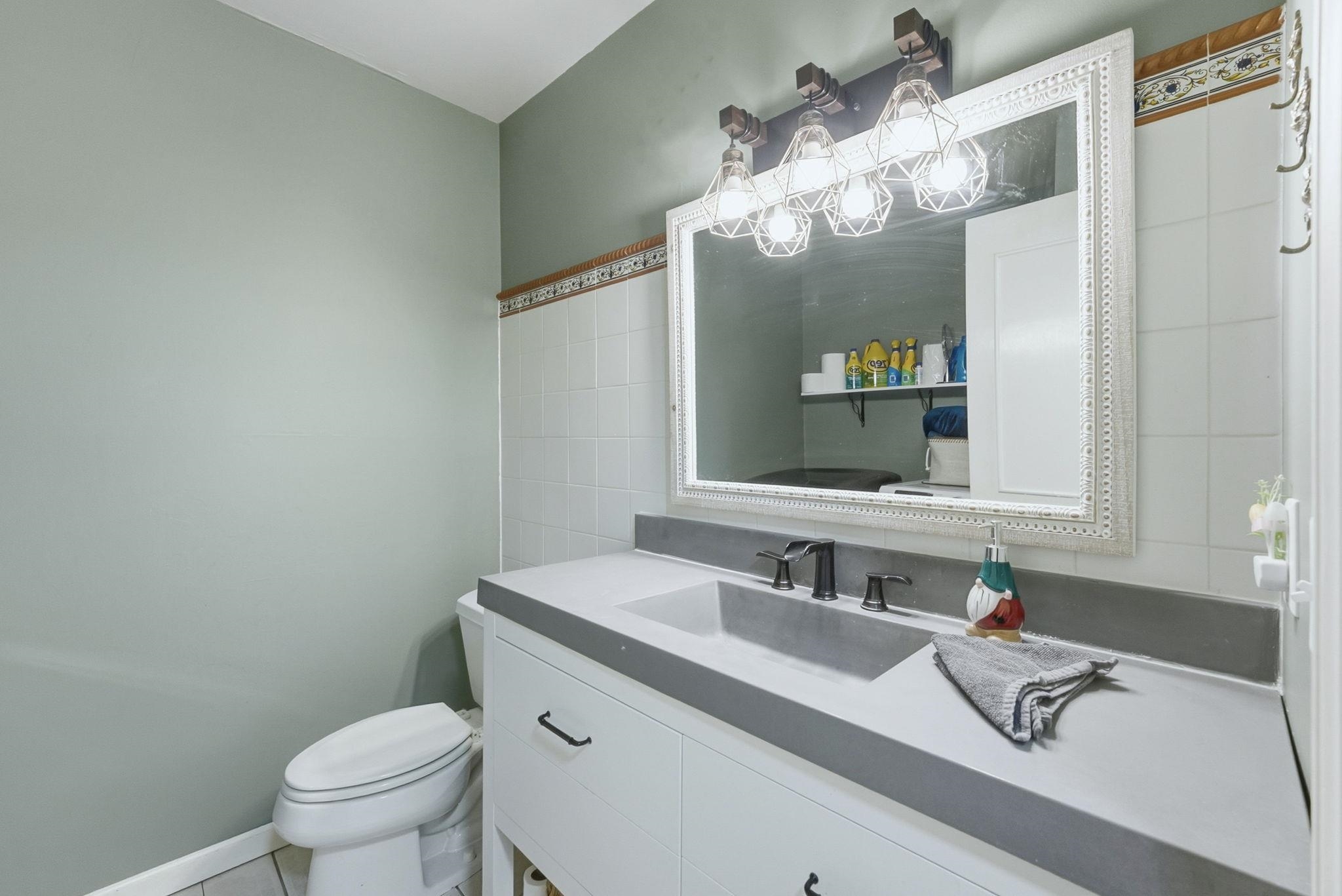 Half bathroom with vanity and tile walls