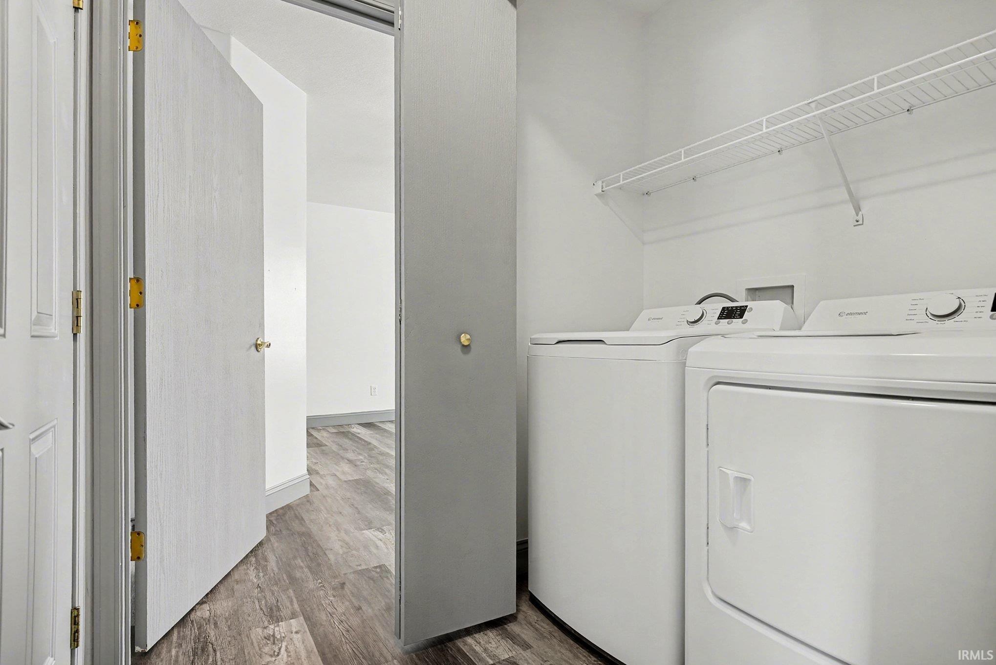 Laundry area with dark wood-style floors and washing machine and dryer