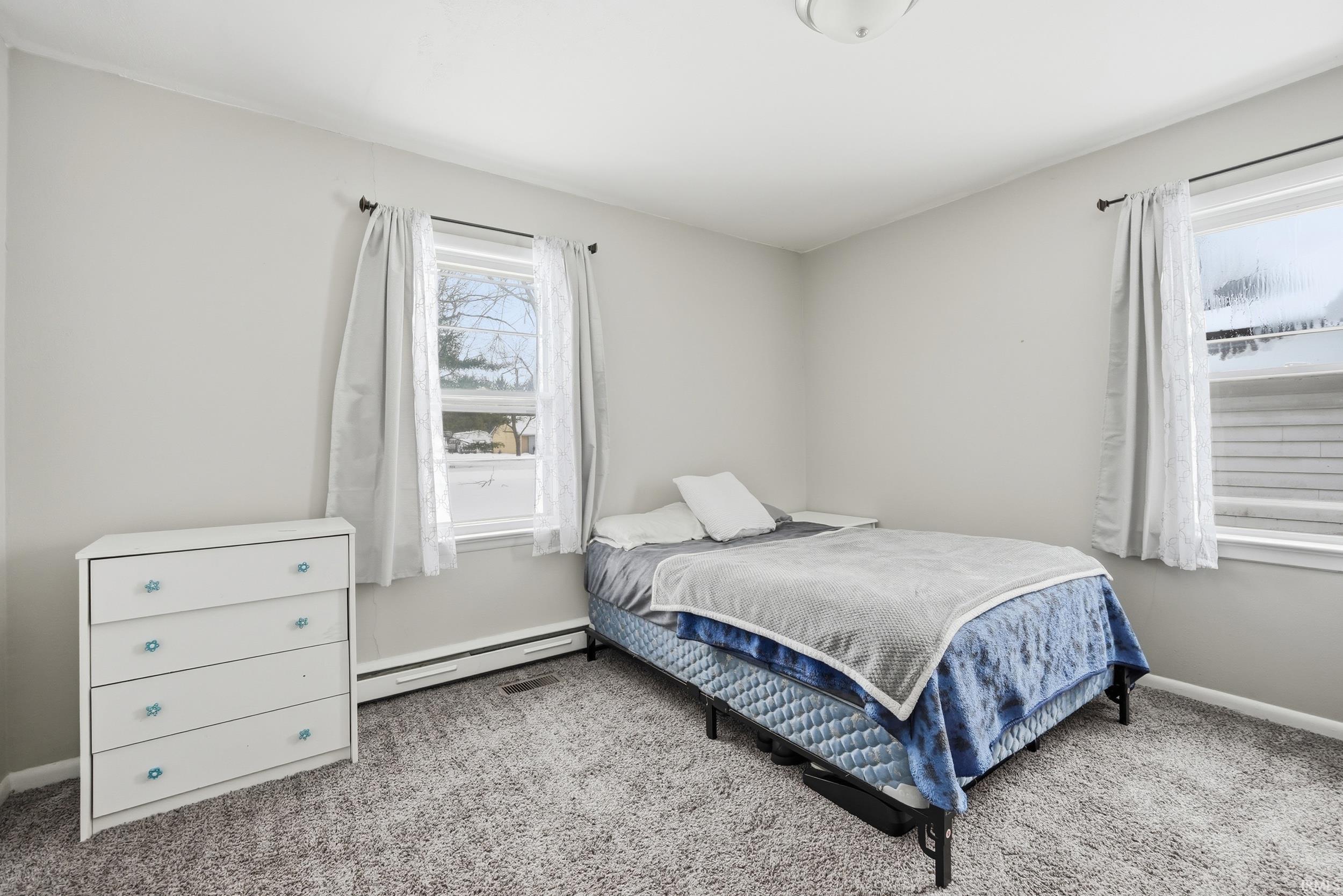 Bedroom featuring a baseboard radiator and carpet floors