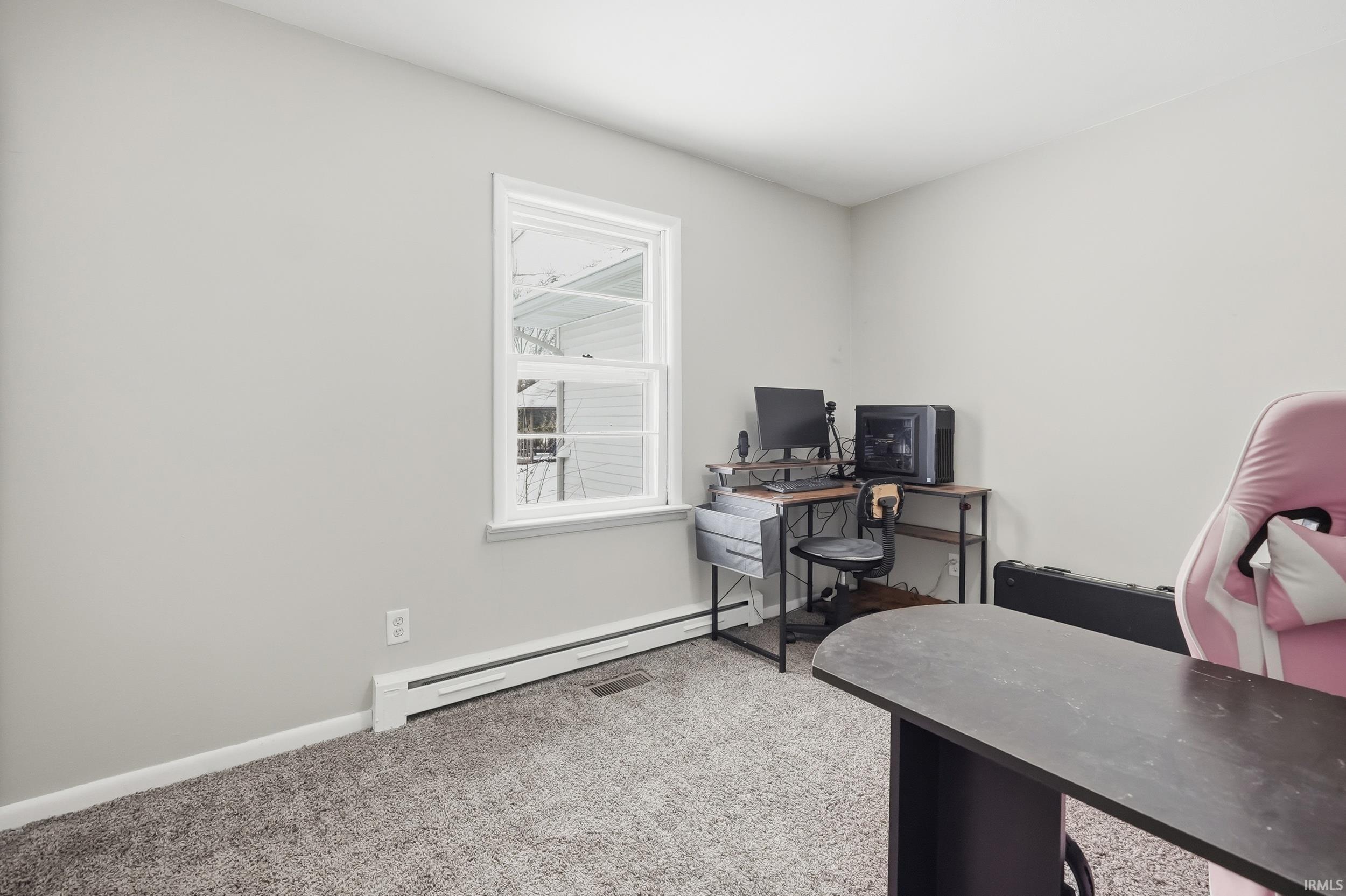 Home office featuring a baseboard radiator and light colored carpet