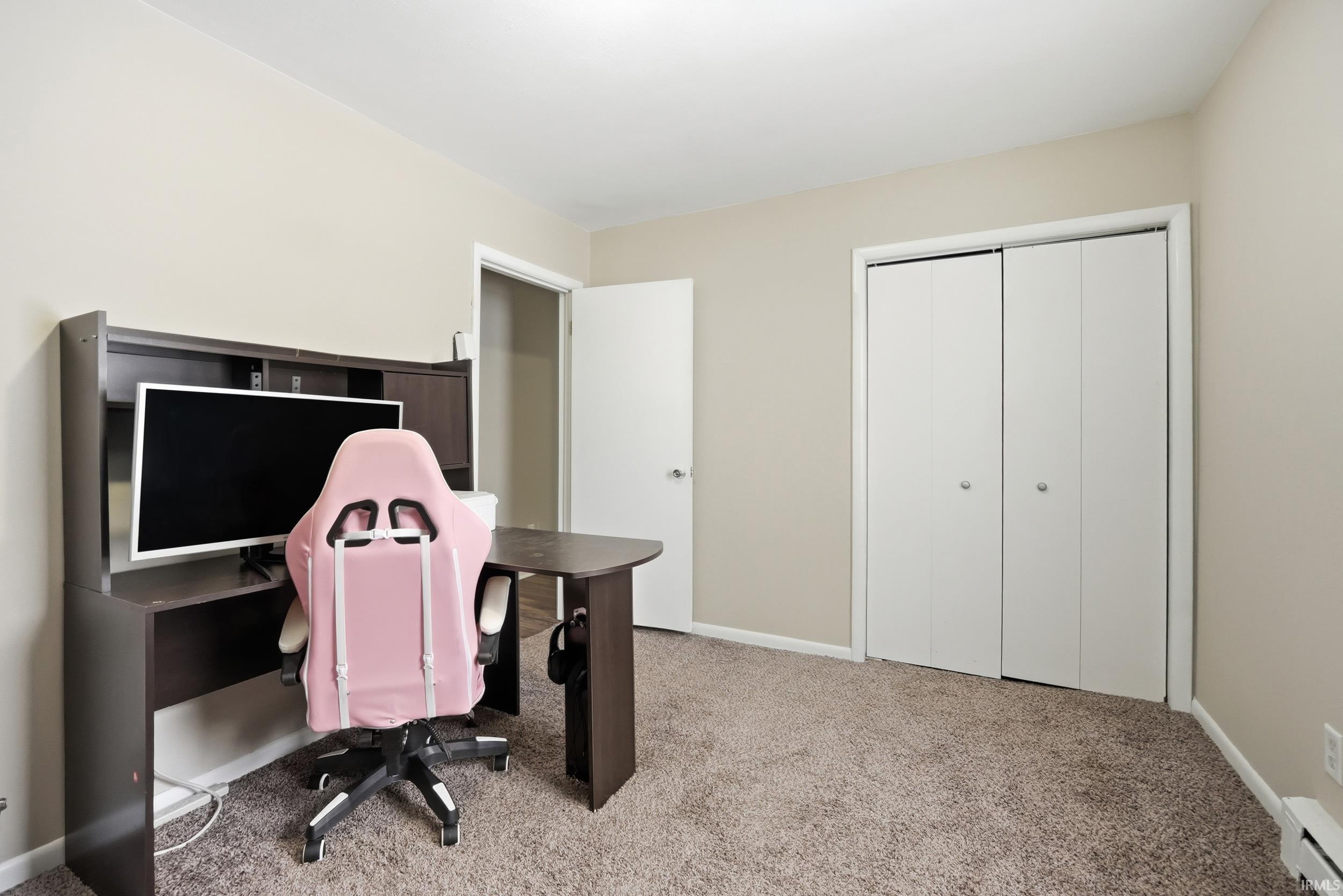 Office area with light colored carpet and a baseboard heating unit