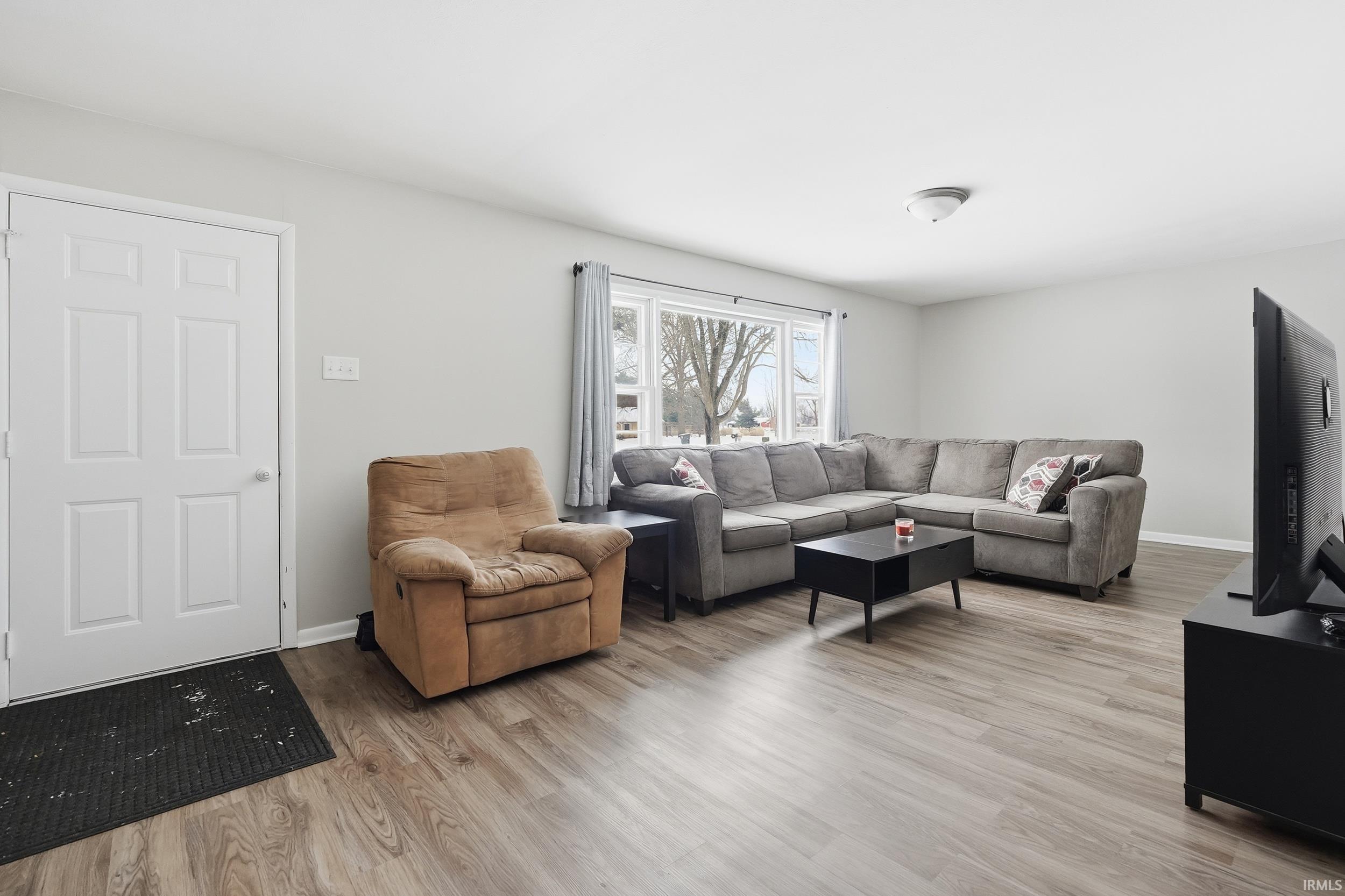 Living area featuring light wood-style flooring and baseboards