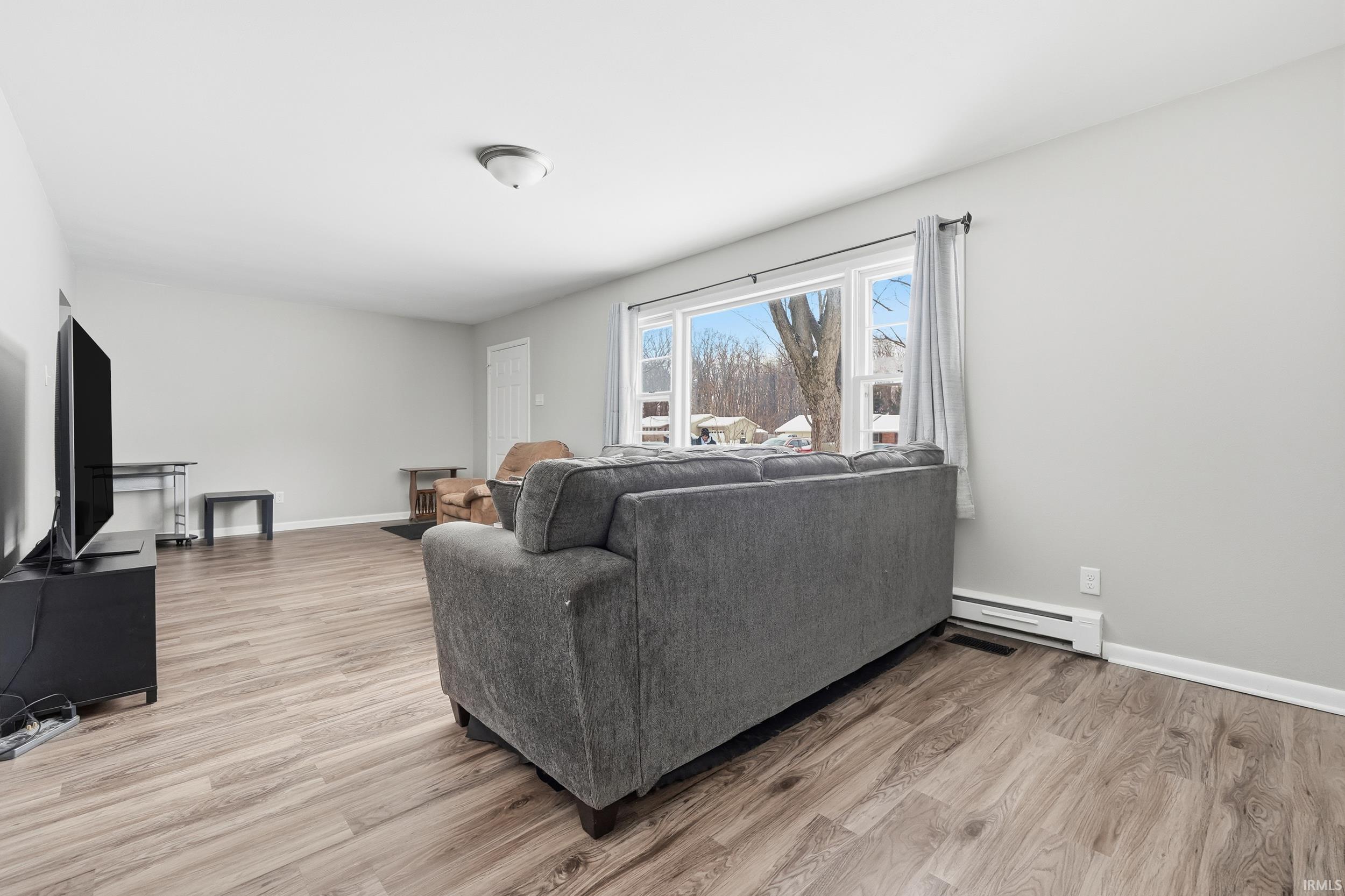 Living area featuring light wood finished floors and a baseboard heating unit