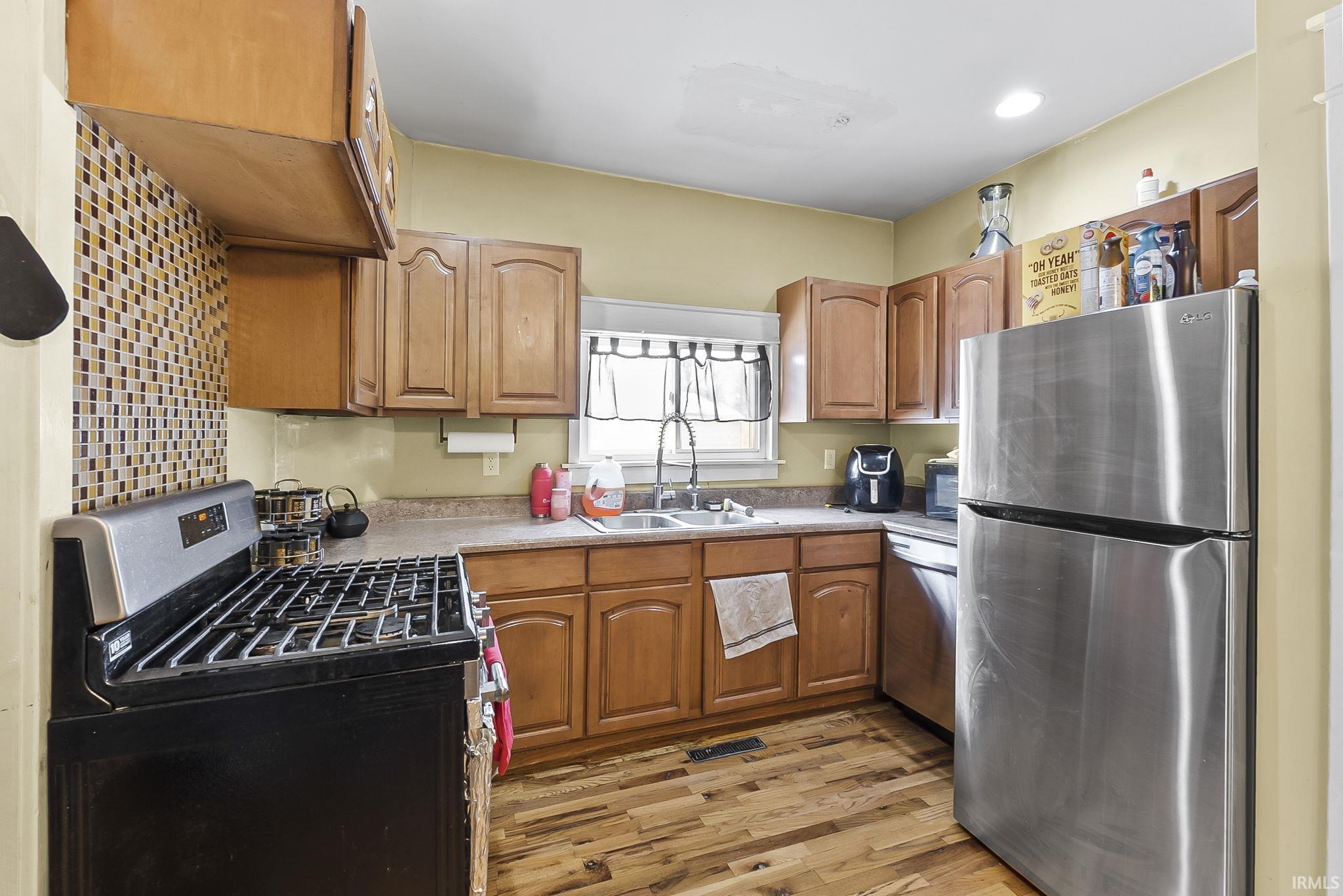 Kitchen with stainless steel appliances, light wood finished floors, light countertops, and wood finish cabinets