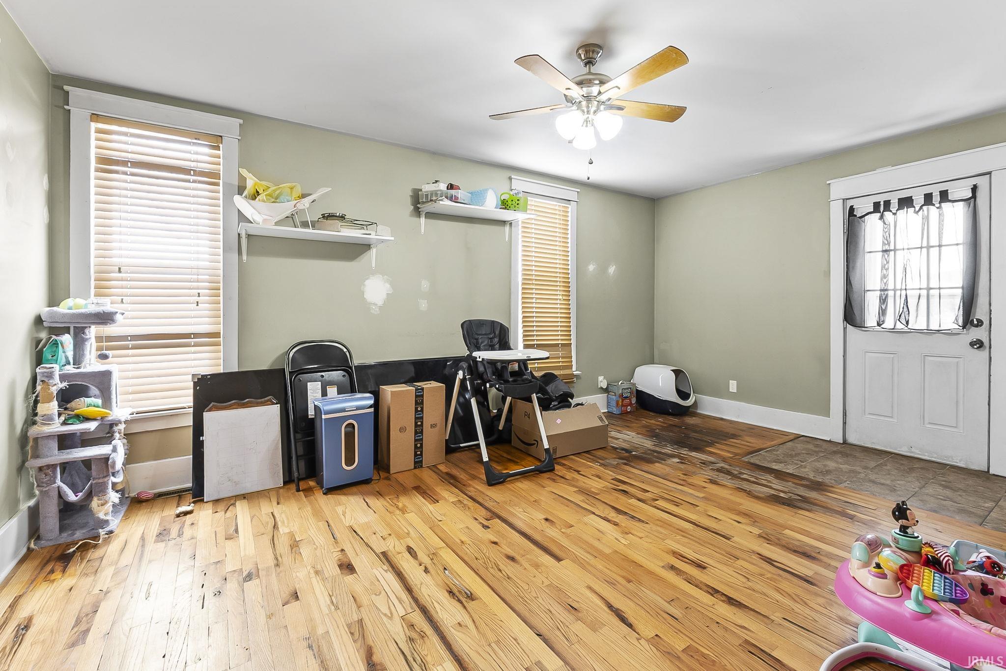 Office area with light wood-style flooring and ceiling fan