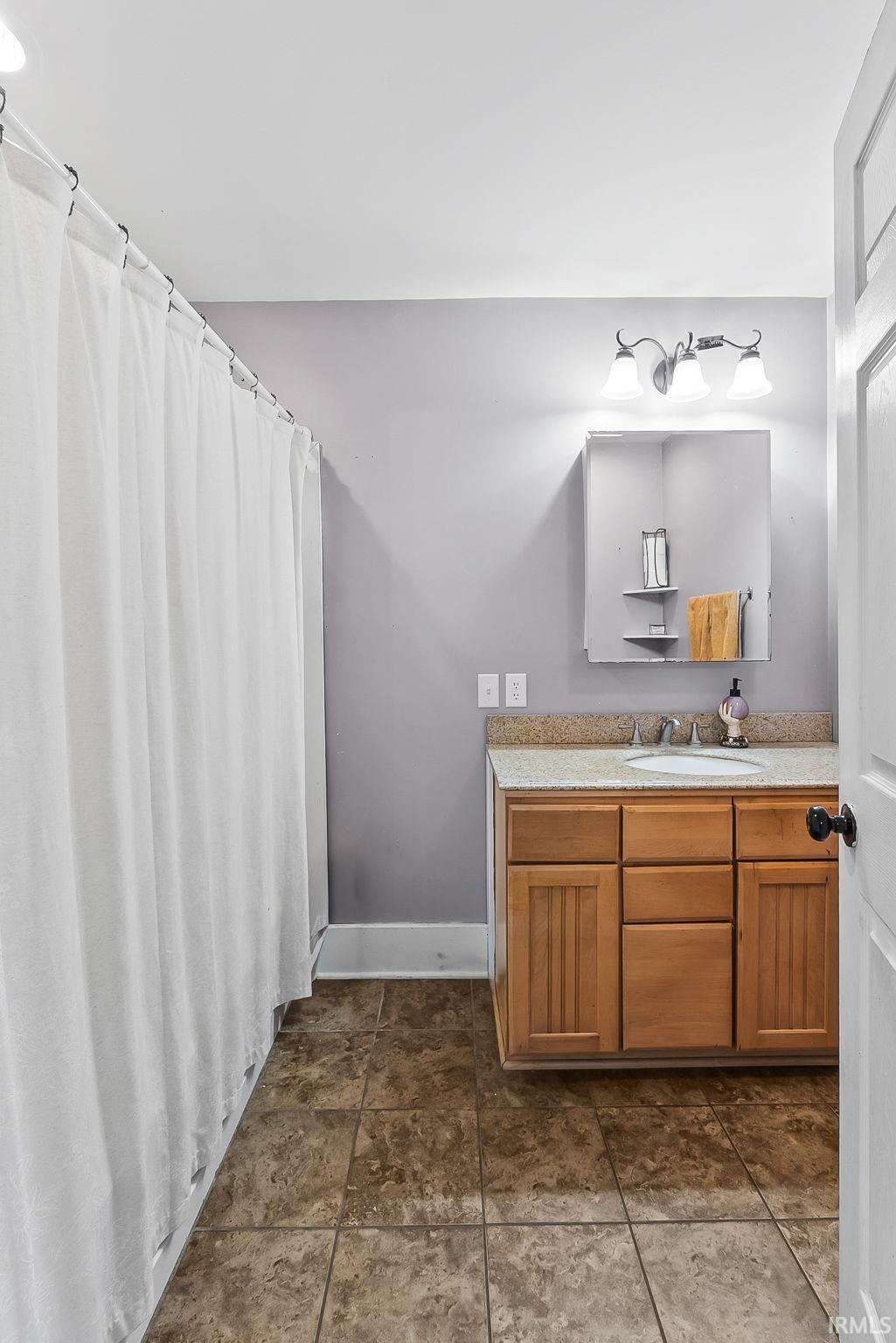 Bathroom with vanity and curtained shower