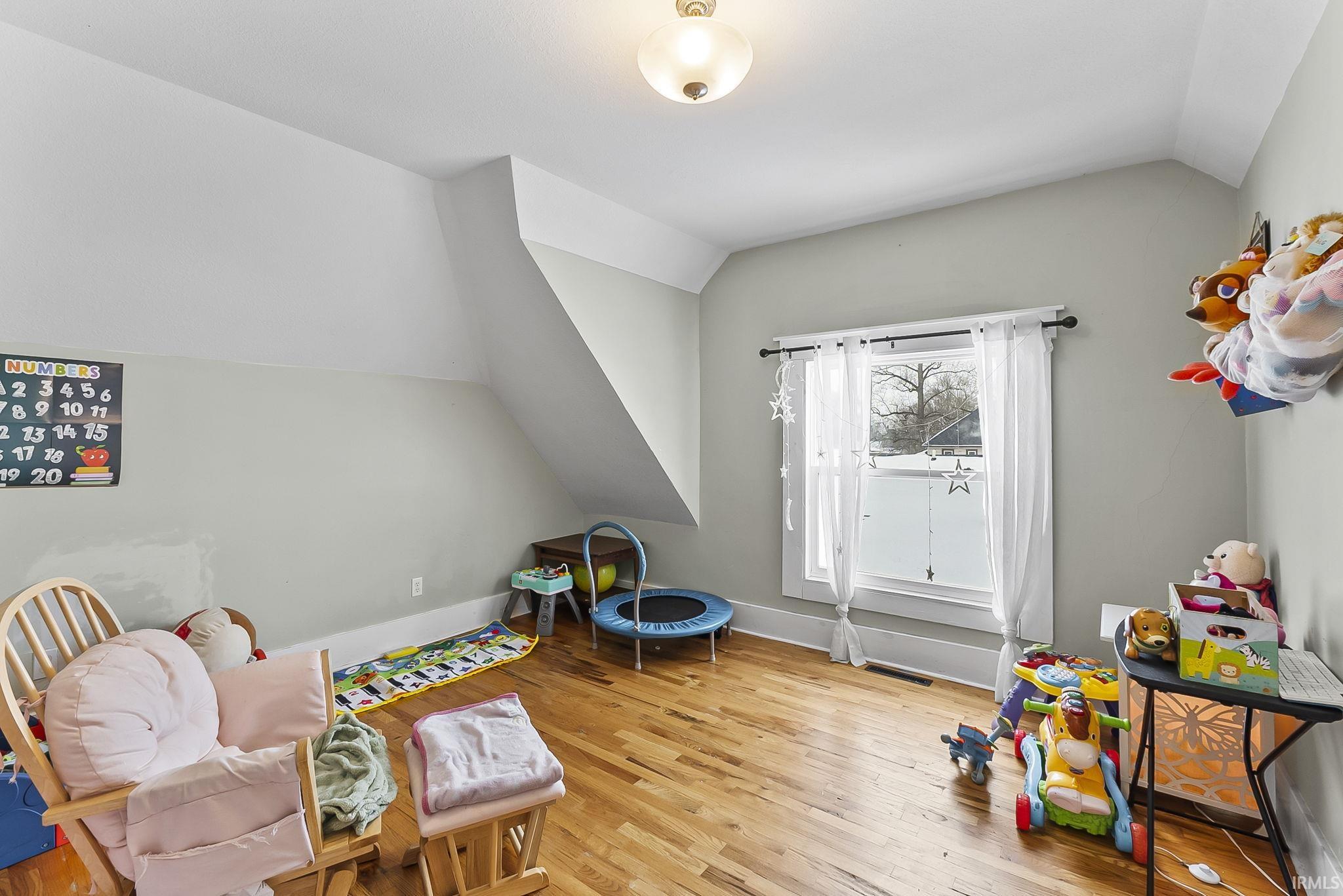 Recreation room featuring vaulted ceiling and light wood-style floors