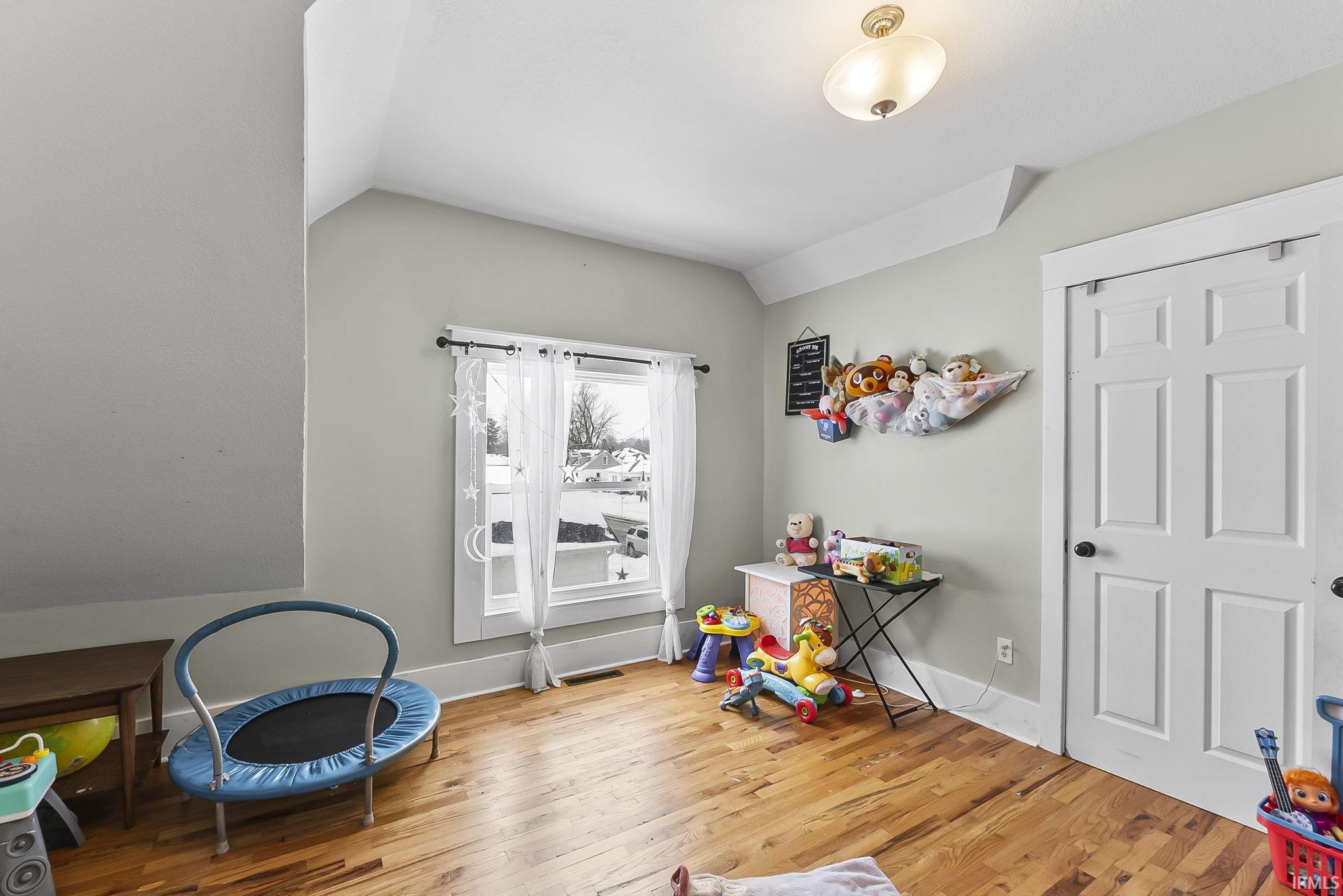 Game room featuring light wood finished floors and lofted ceiling