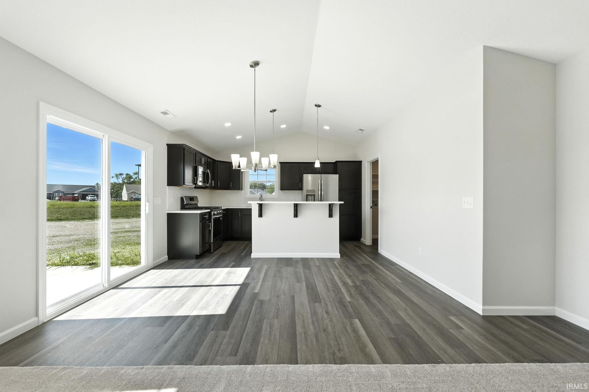 Kitchen featuring light countertops, stainless steel appliances, a center island, and open floor plan