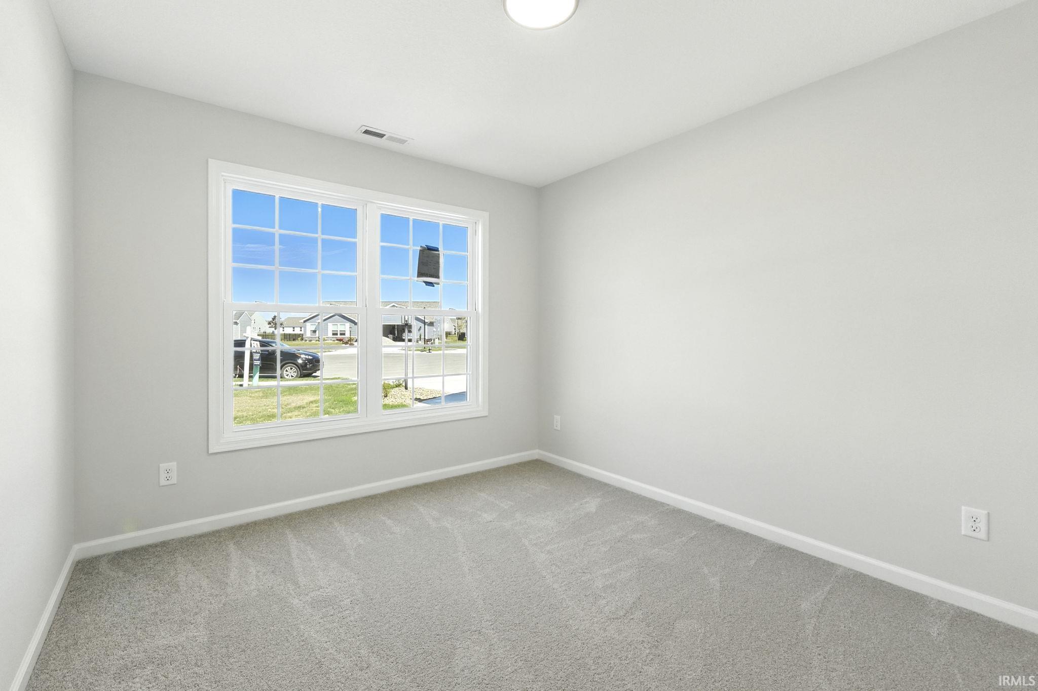 Carpeted spare room with baseboards