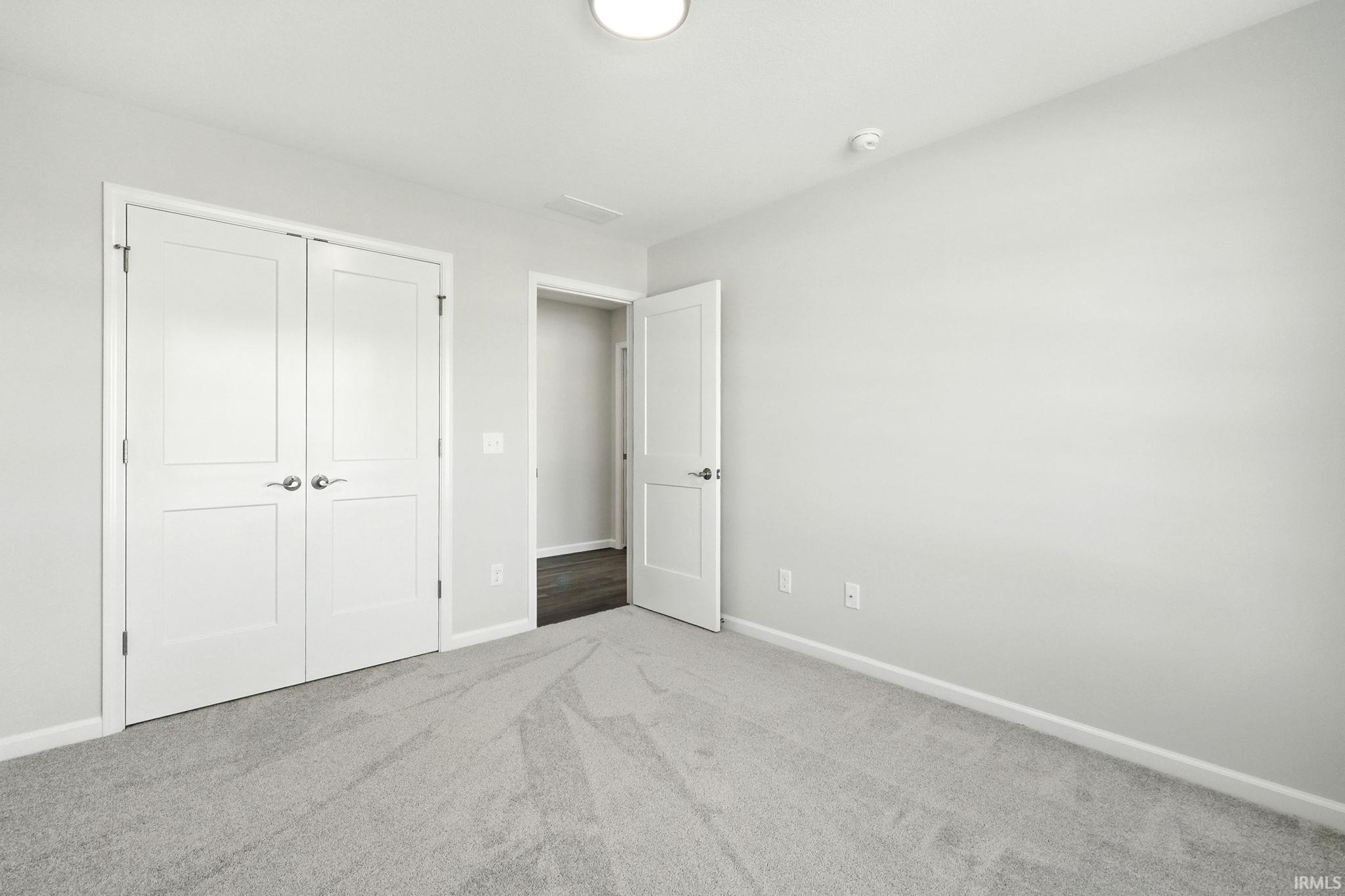 Unfurnished bedroom with carpet flooring and a closet