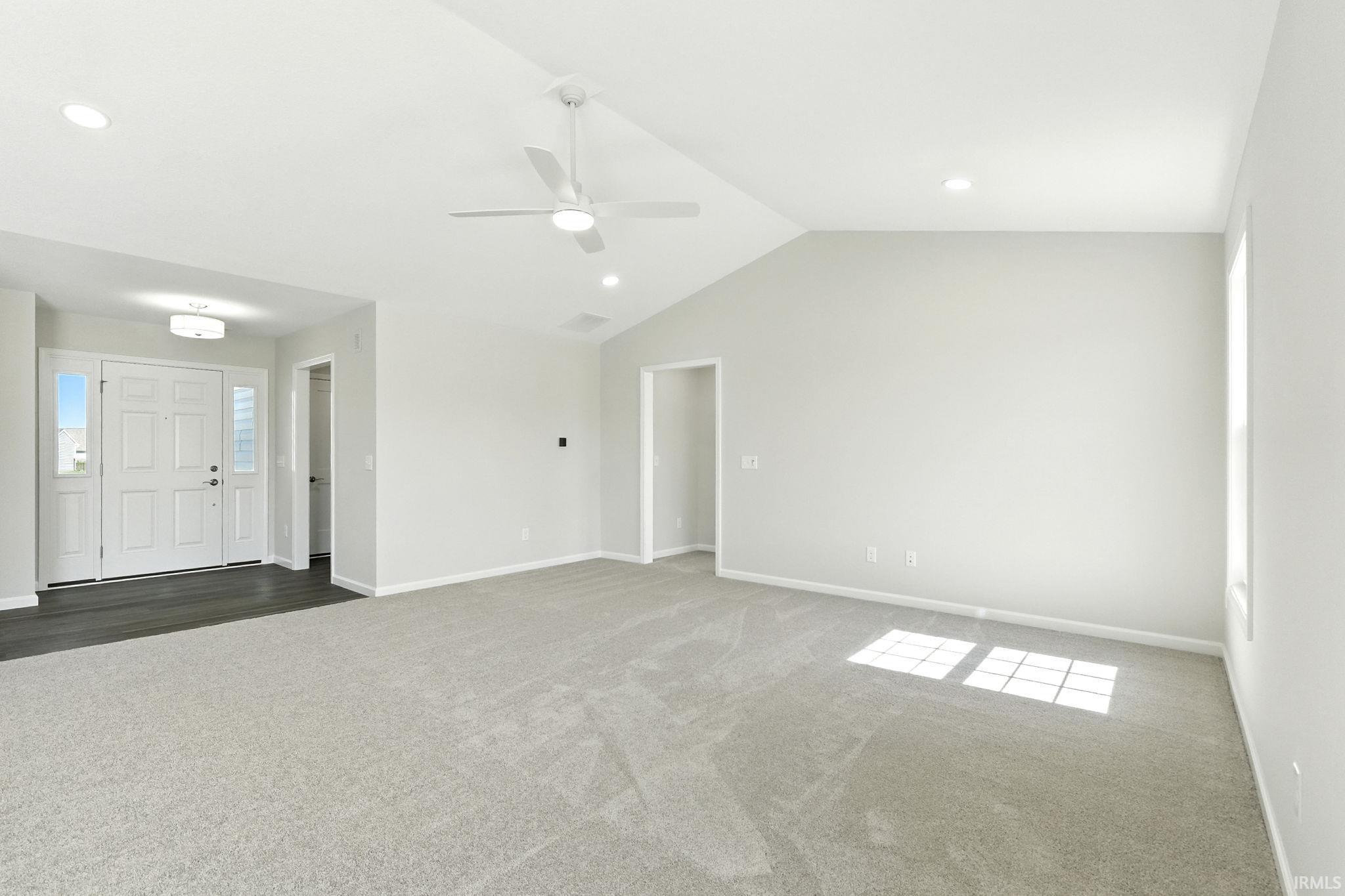 Unfurnished living room featuring carpet, a ceiling fan, and recessed lighting