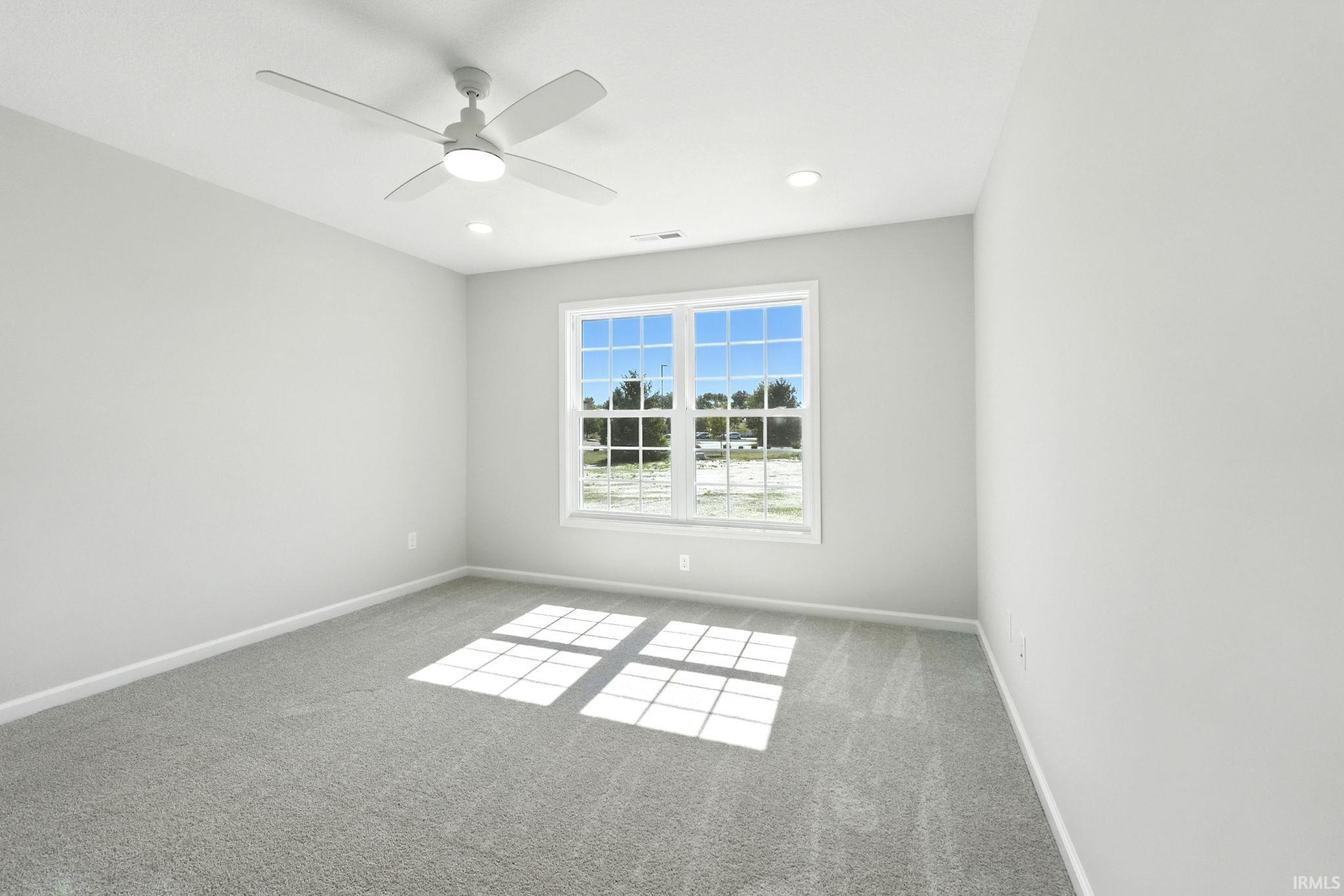 Carpeted spare room with a ceiling fan and recessed lighting