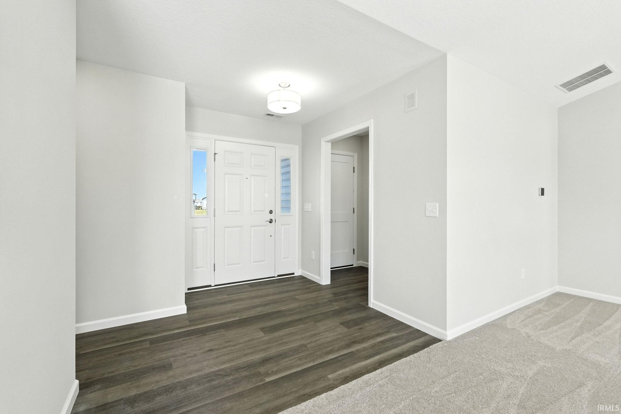 Foyer entrance featuring baseboards and dark wood-style floors