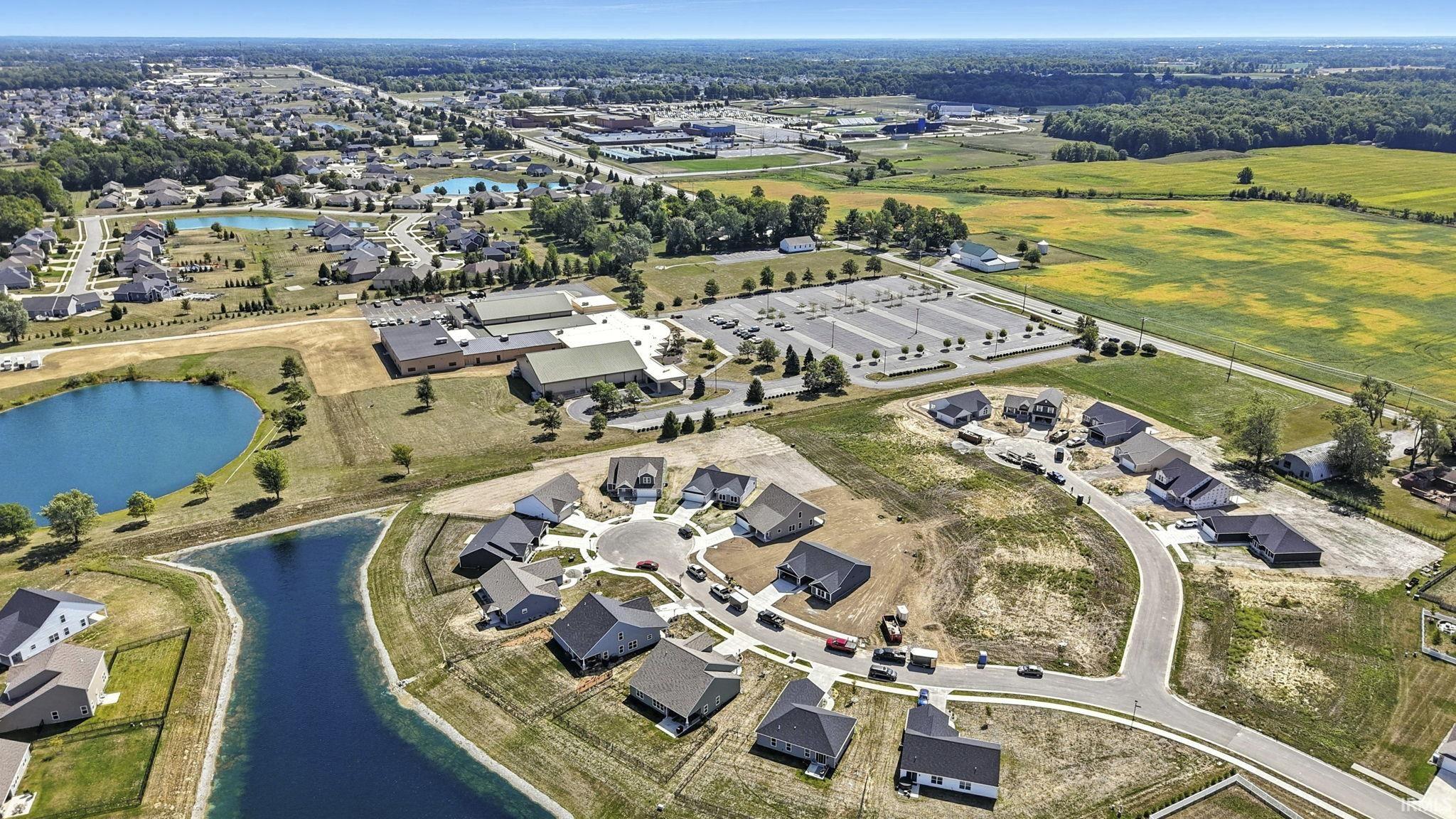 Aerial view of property and surrounding area with a nearby body of water and nearby suburban area