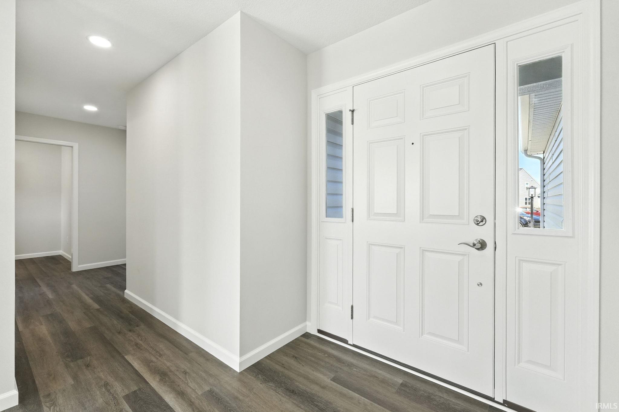 Foyer with dark wood-style flooring and recessed lighting
