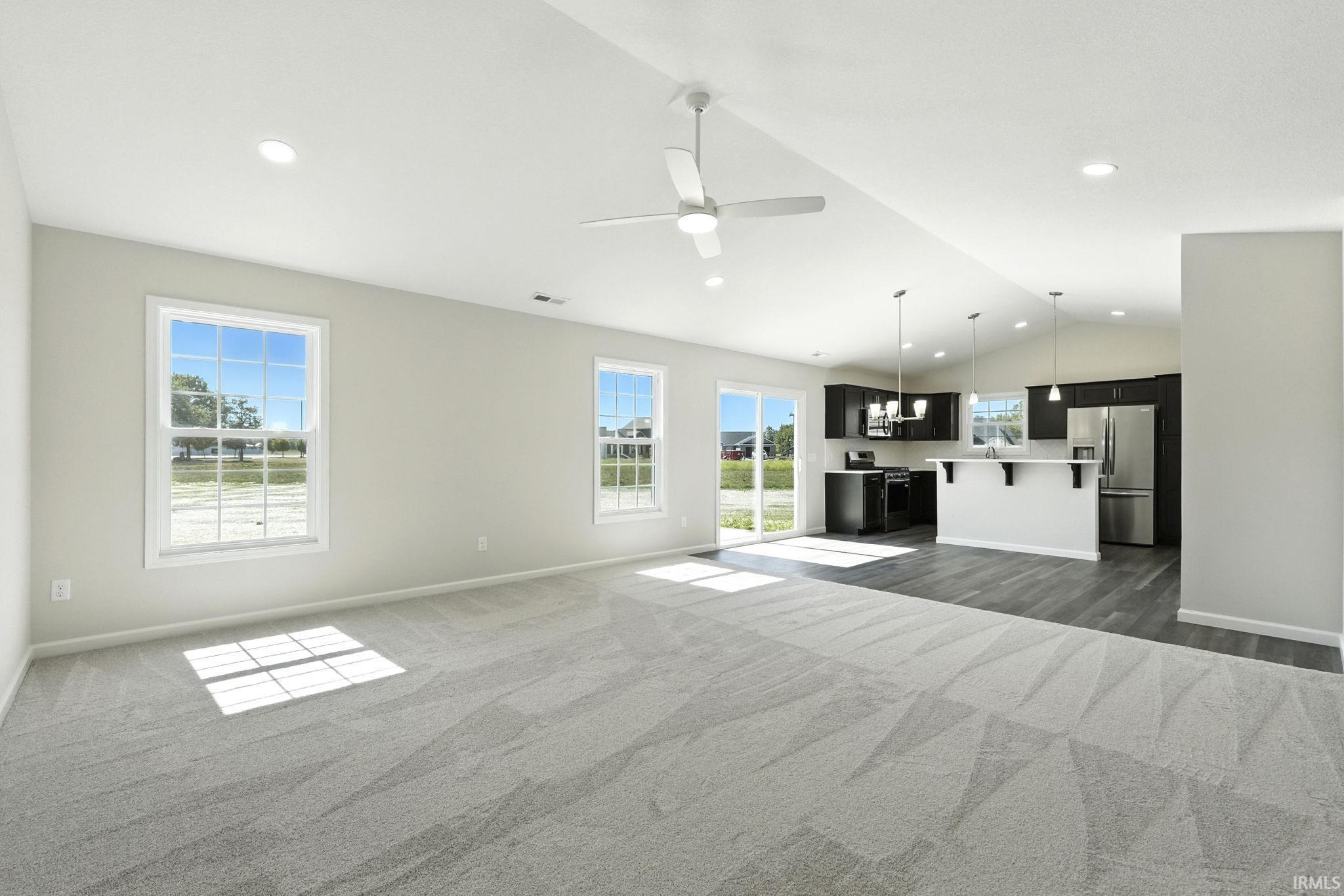 Unfurnished living room featuring a ceiling fan, dark colored carpet, and recessed lighting