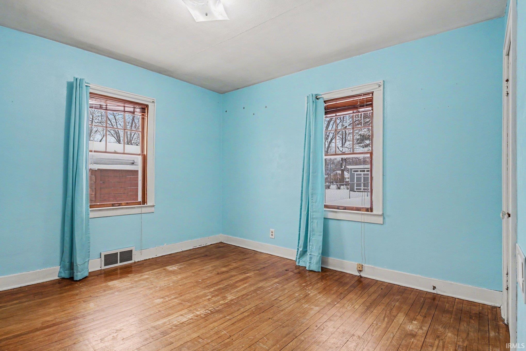 Unfurnished room featuring wood-type flooring and plenty of natural light