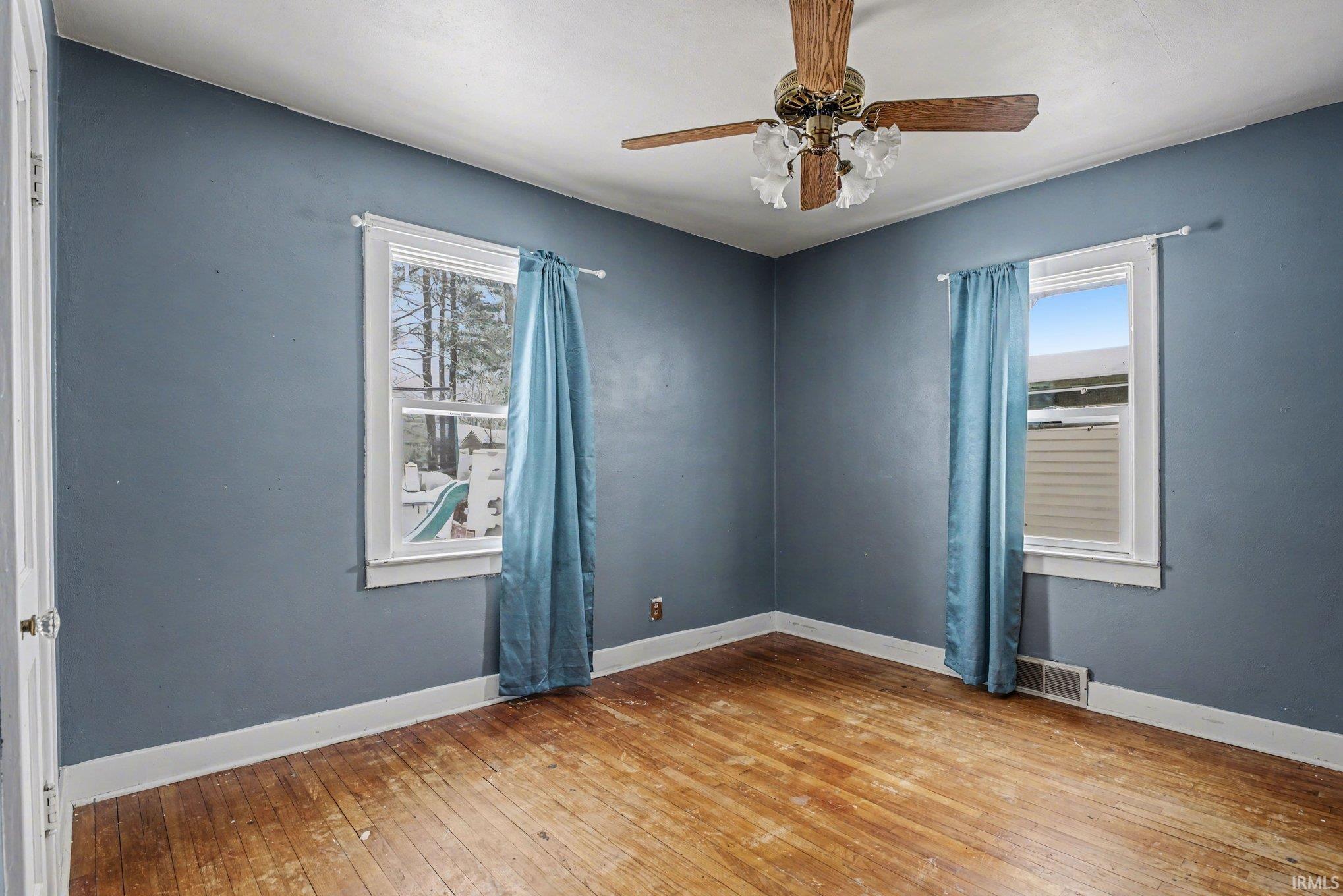 Empty room with light wood-style flooring and ceiling fan