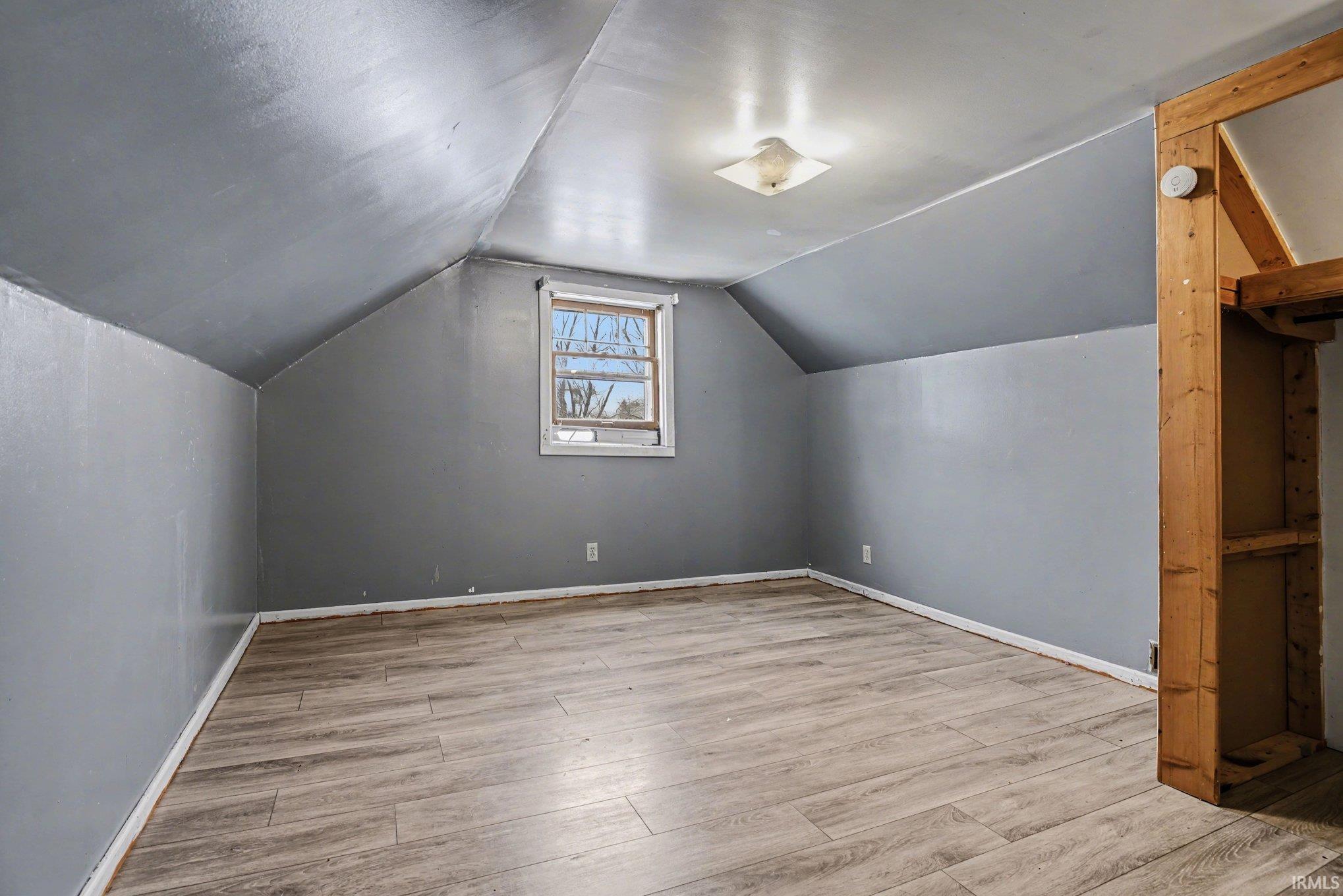 Bonus room with light wood-style flooring