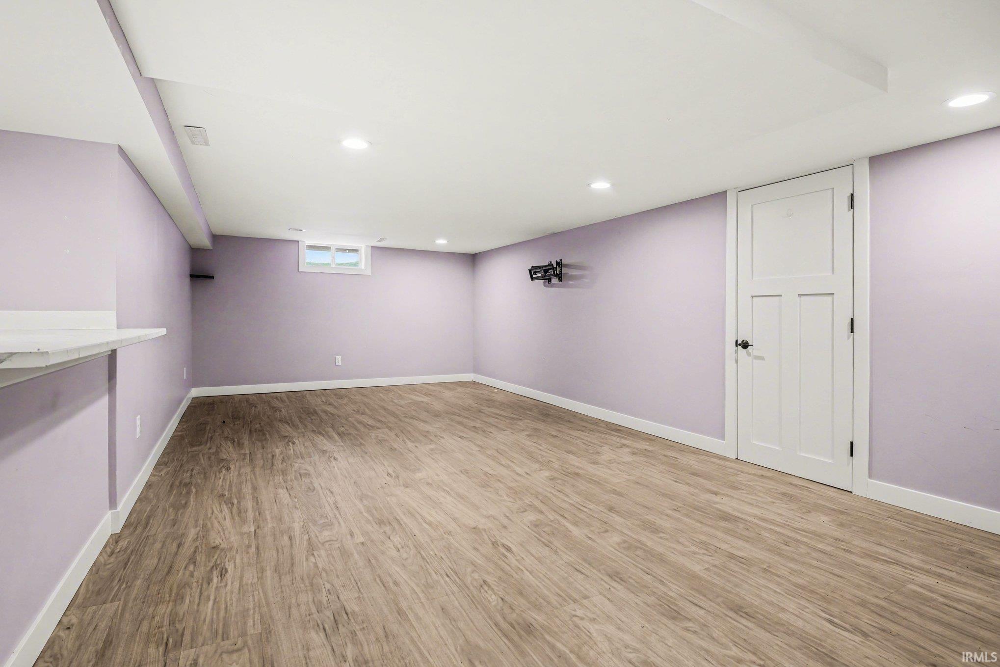 Below grade area featuring light wood finished floors and recessed lighting