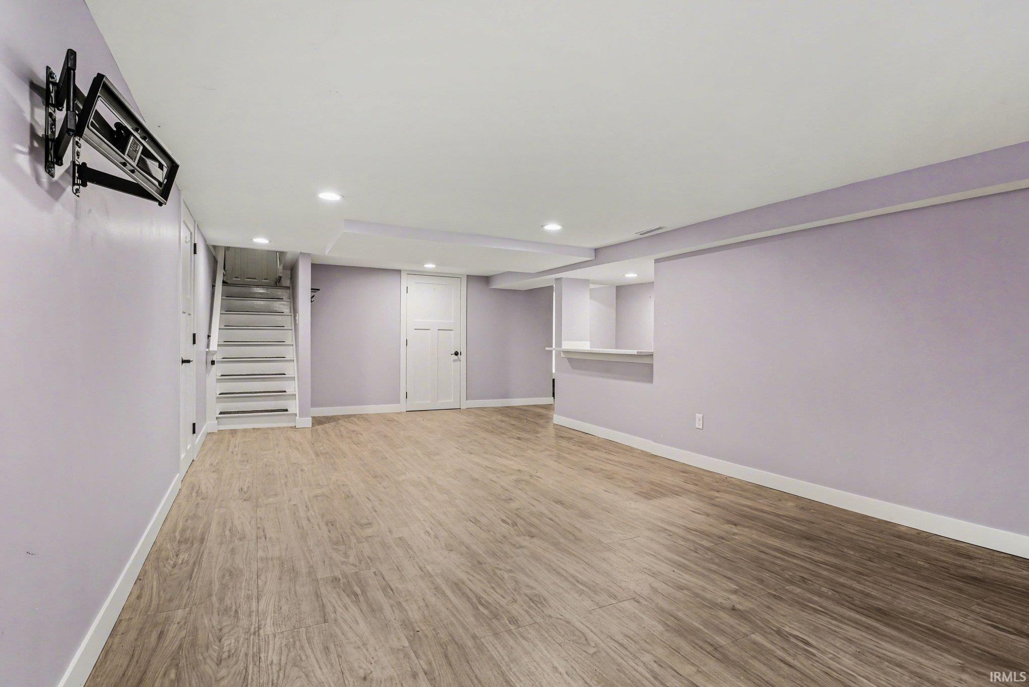 Finished basement featuring light wood finished floors and recessed lighting