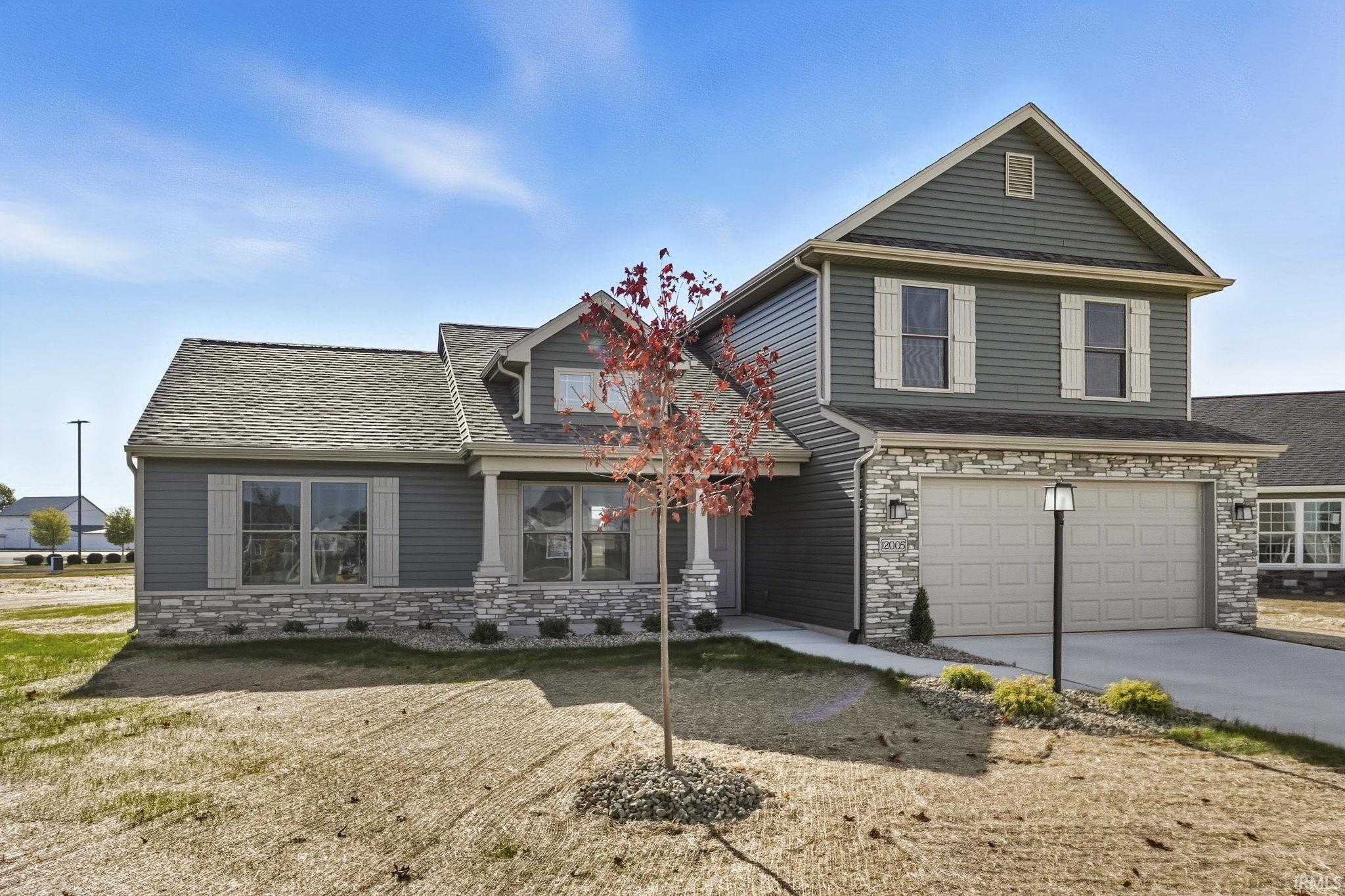 View of front of property with stone siding, a garage, concrete driveway, and a shingled roof