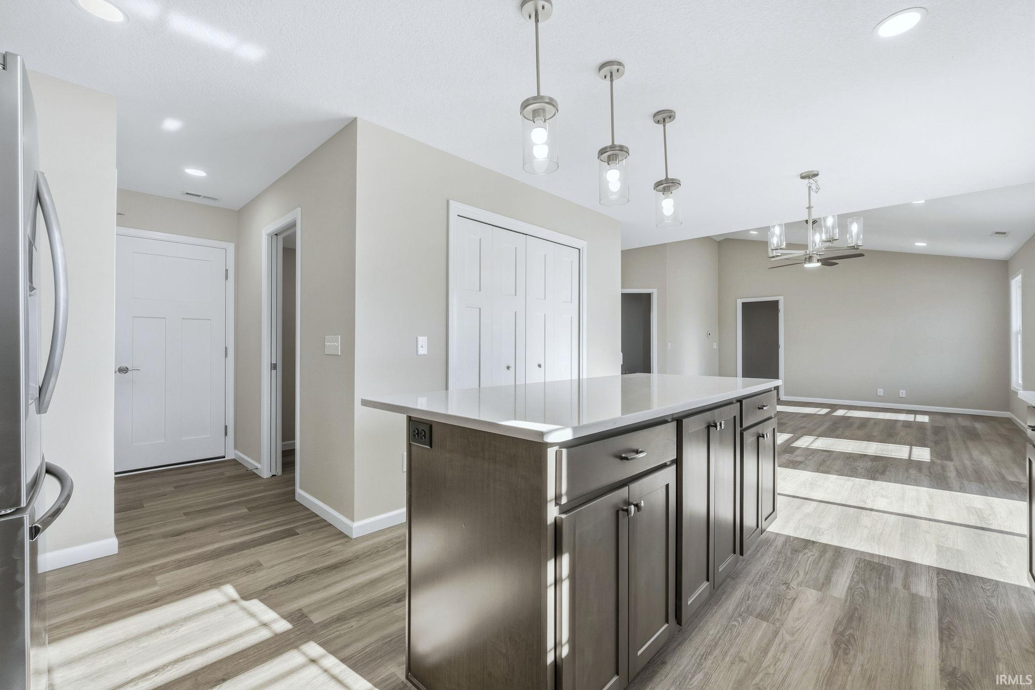 Kitchen featuring a kitchen island, freestanding refrigerator, light wood-style flooring, and open floor plan