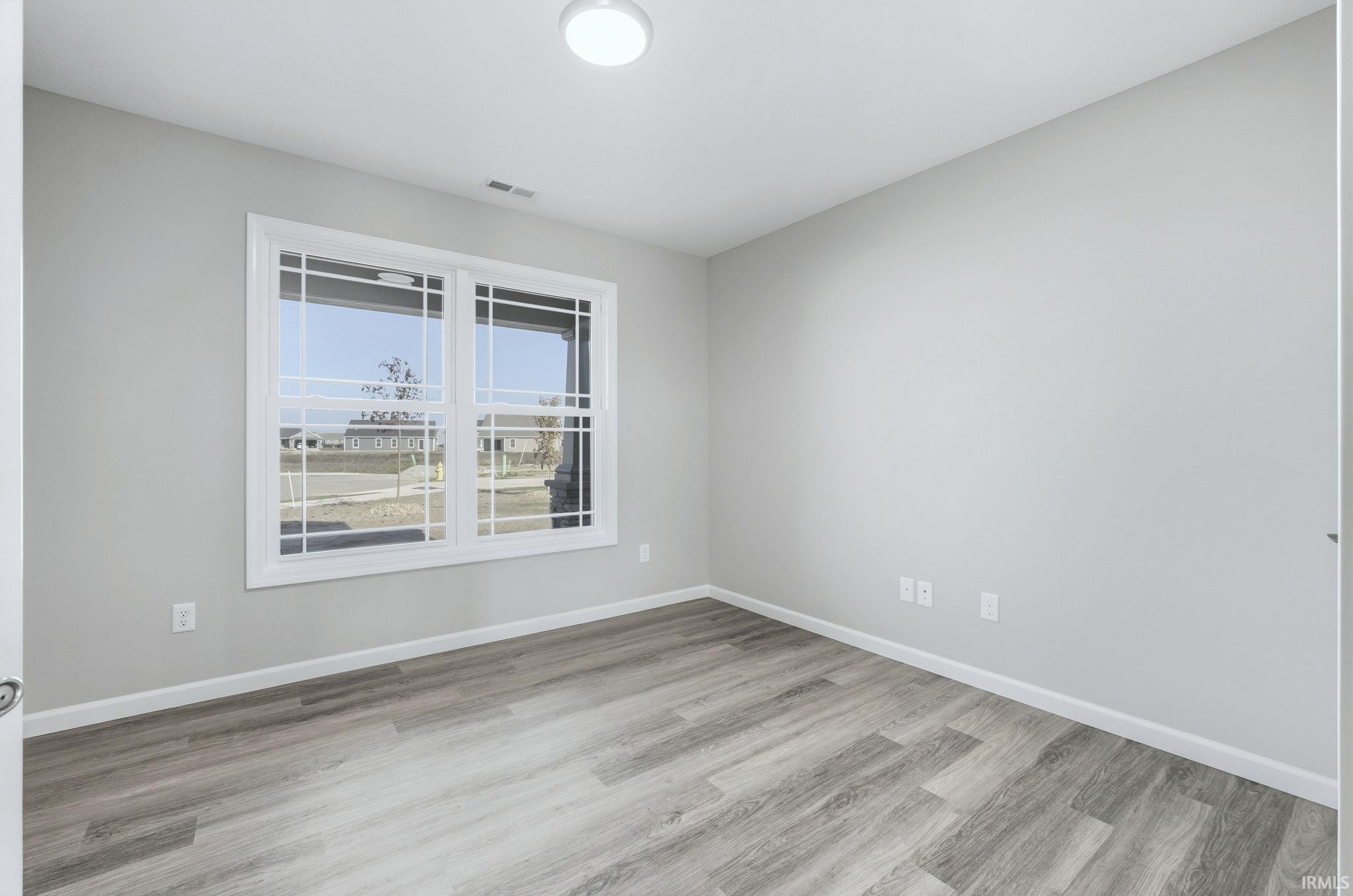 Empty room with baseboards and light wood-type flooring
