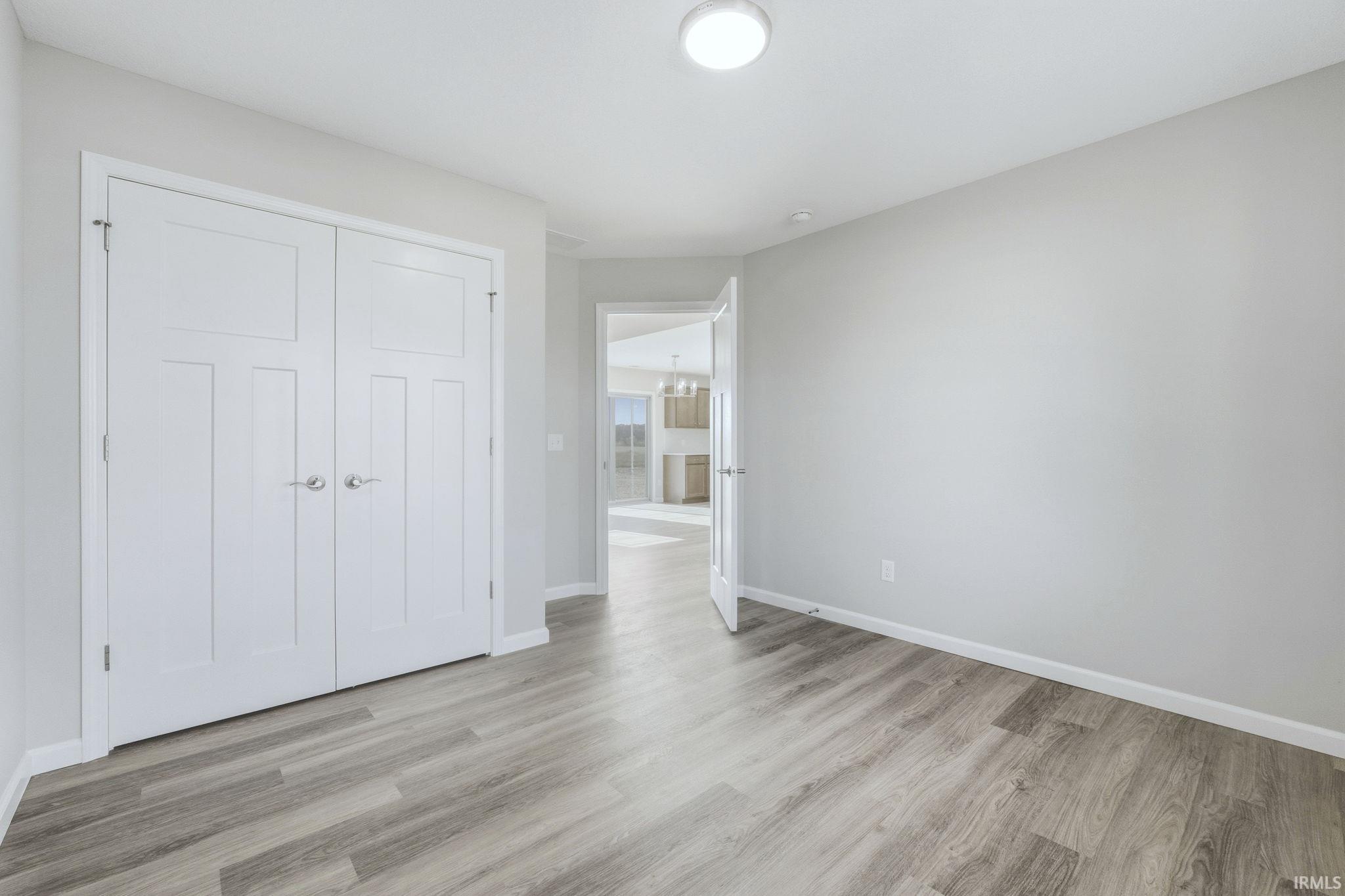 Unfurnished bedroom featuring light wood-style floors and a closet
