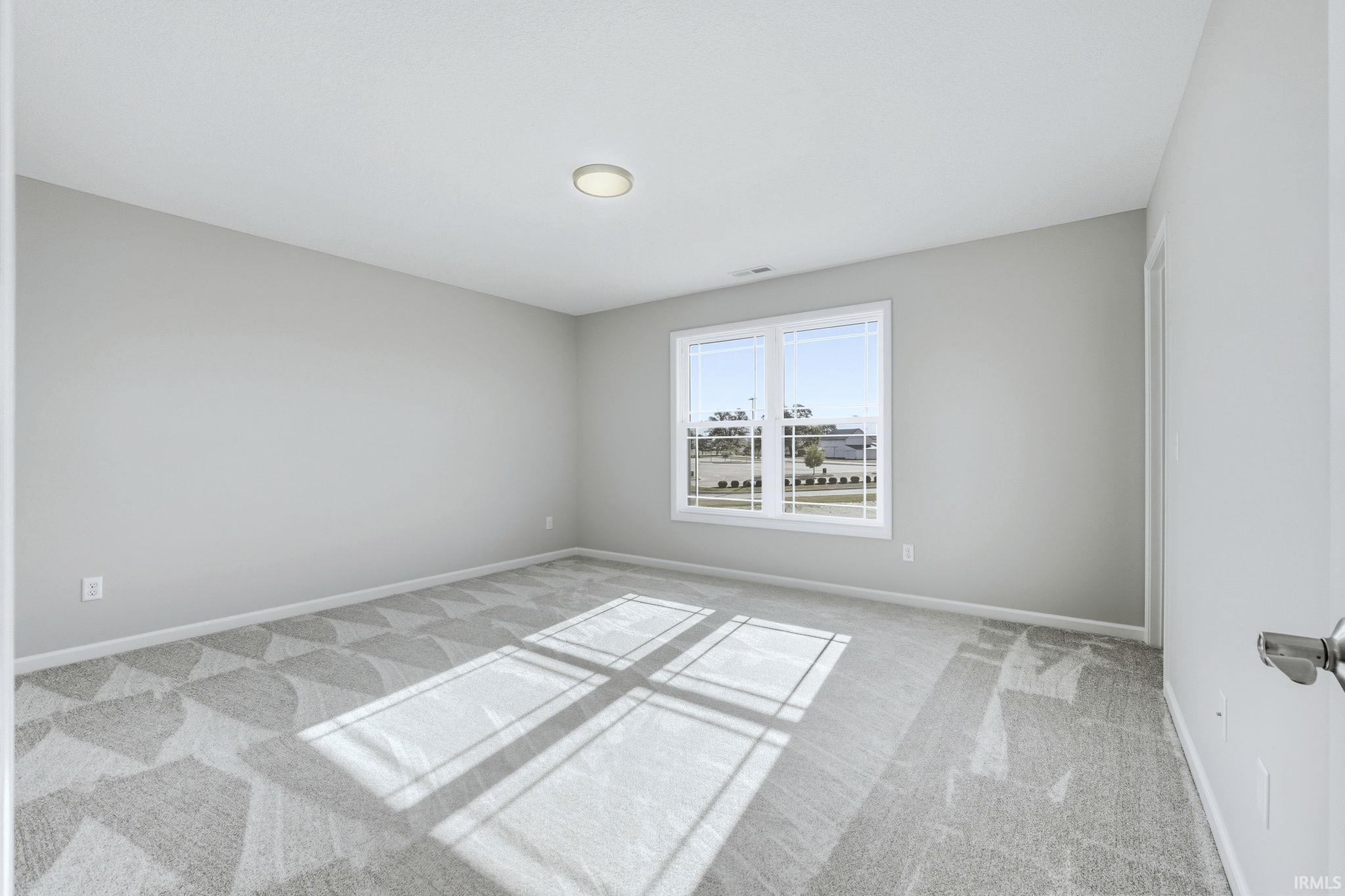 Spare room featuring light colored carpet