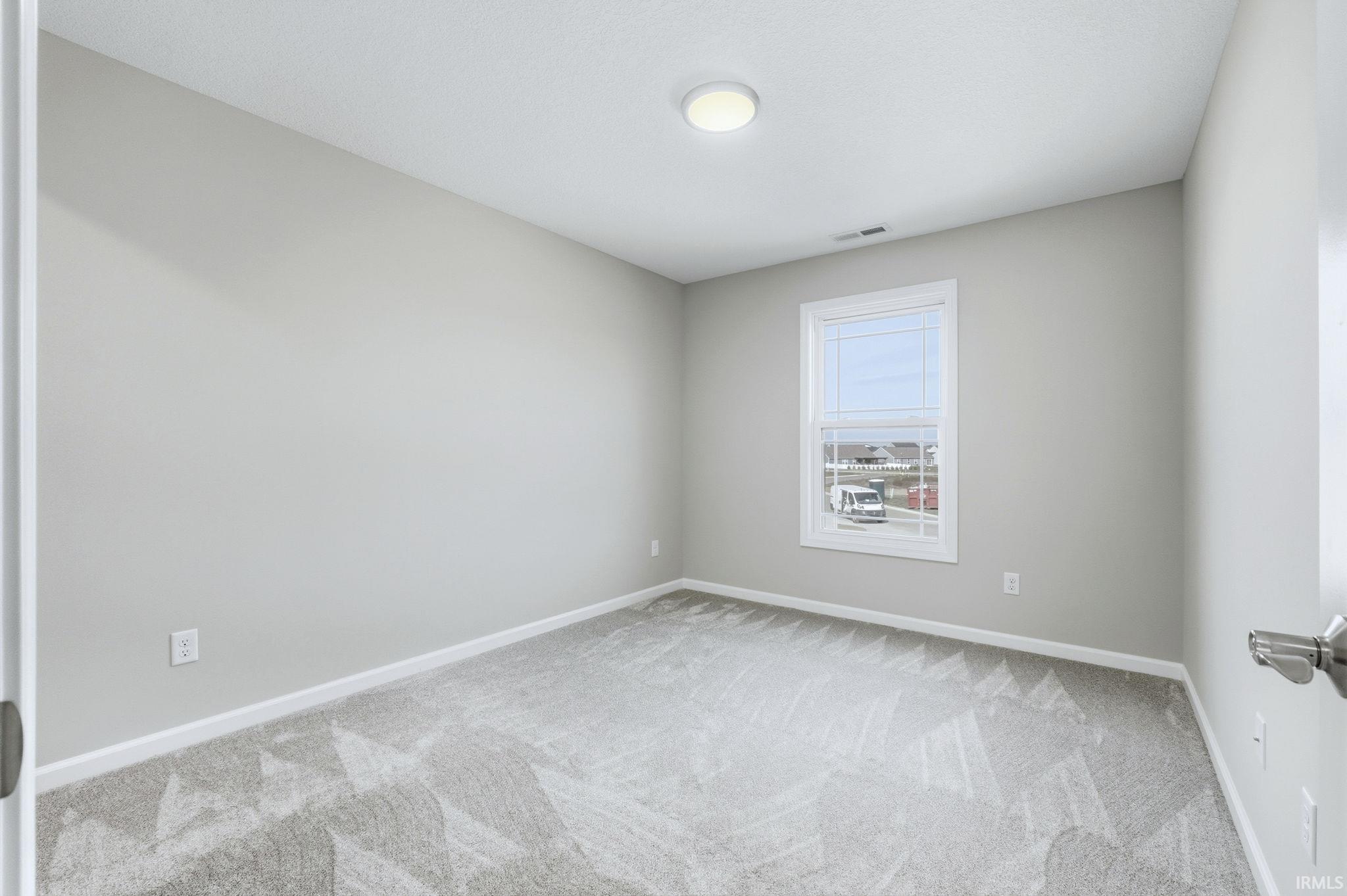 Carpeted empty room featuring baseboards
