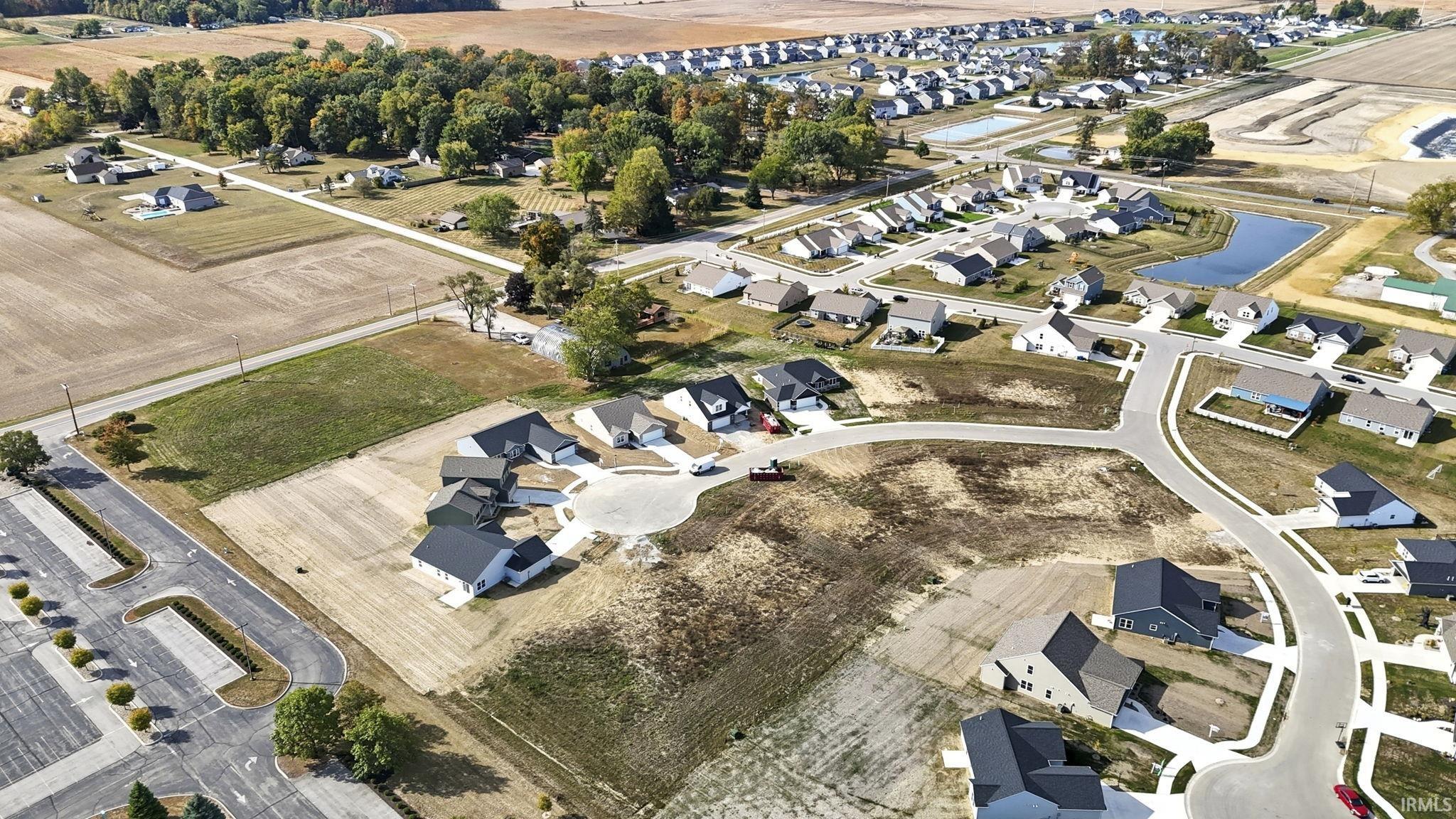 Aerial view of property and surrounding area with a nearby body of water and nearby suburban area