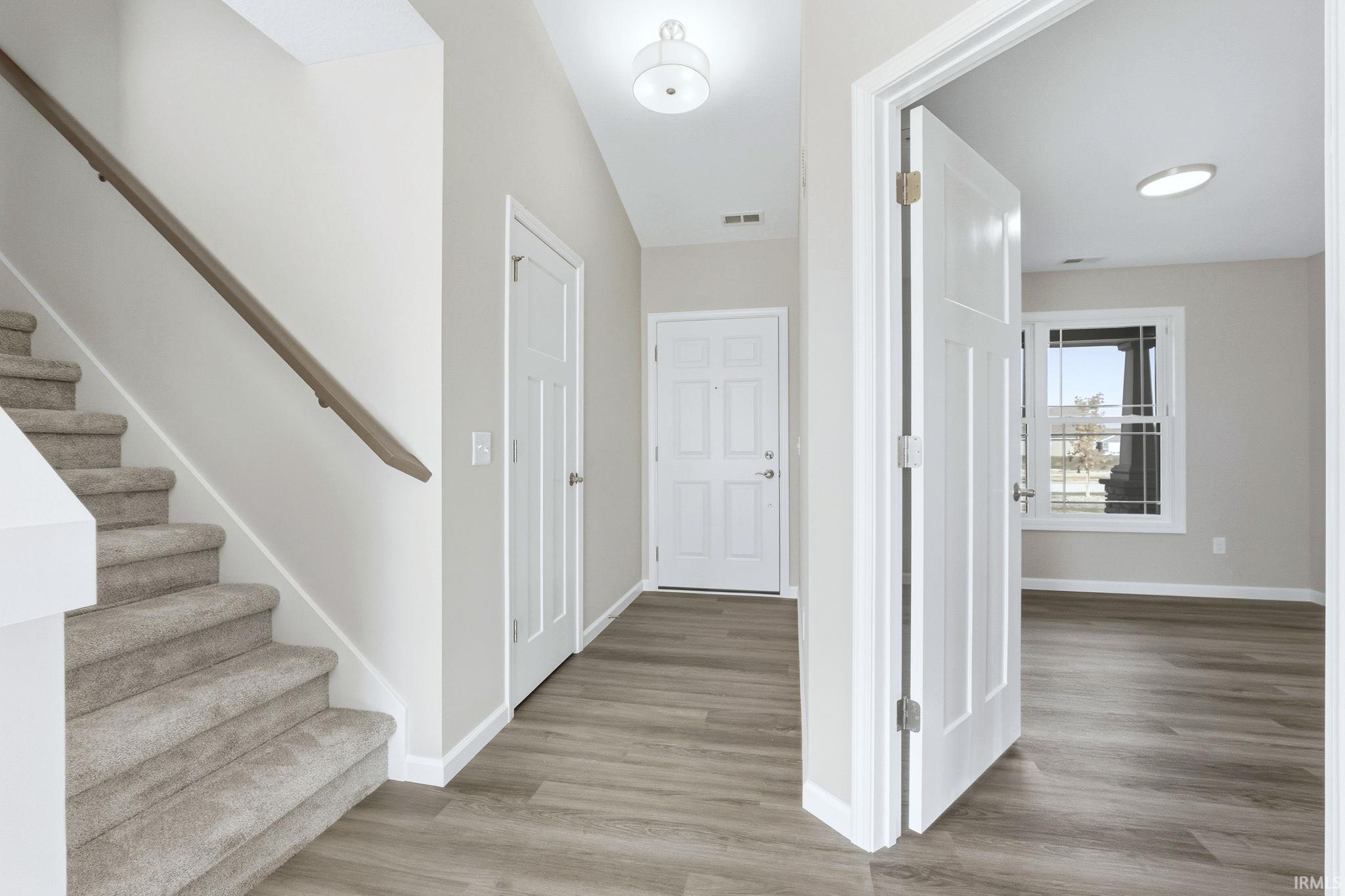 Corridor with stairs and light wood-type flooring