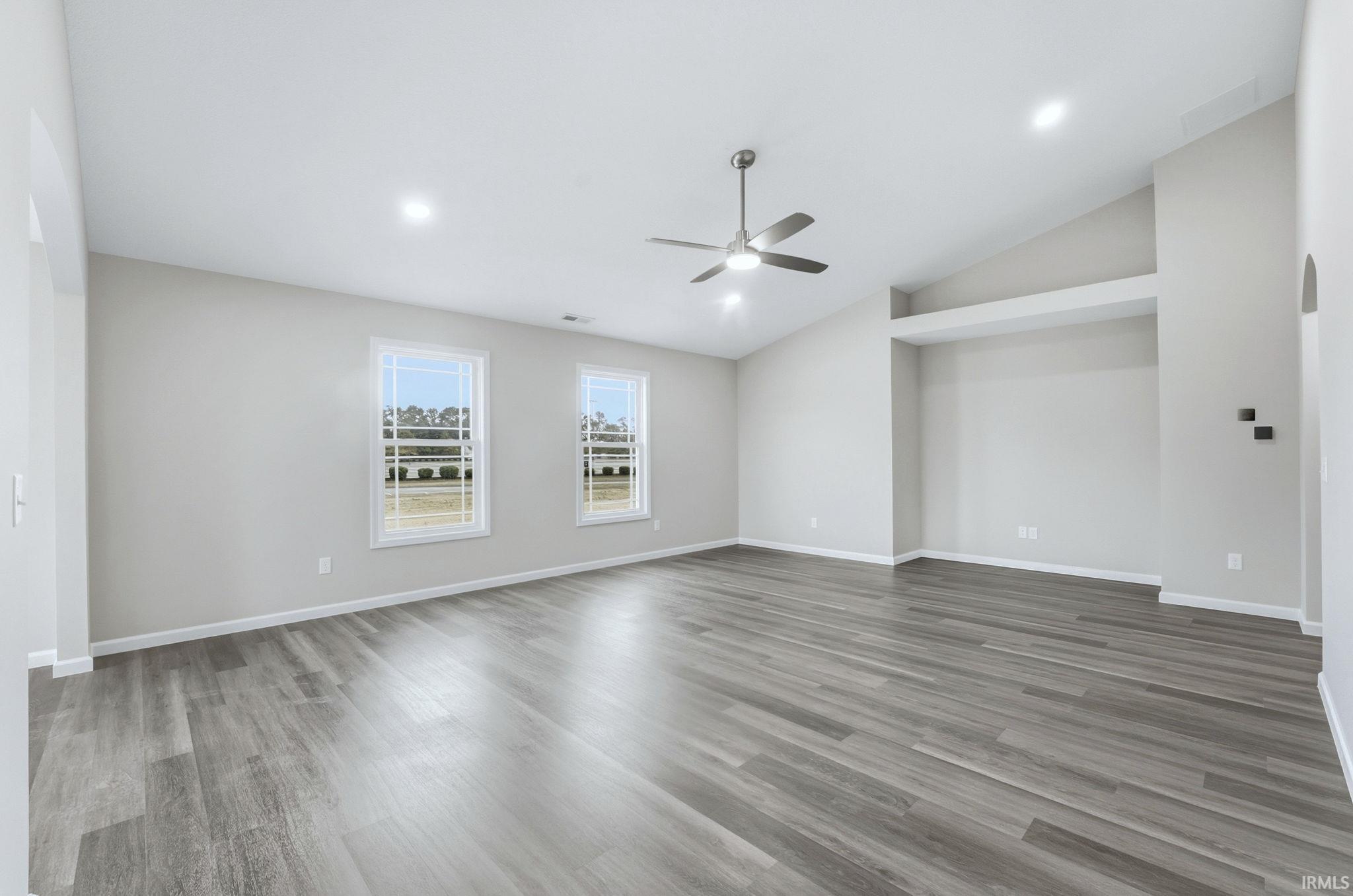 Empty room featuring ceiling fan, light wood-type flooring, lofted ceiling, and recessed lighting