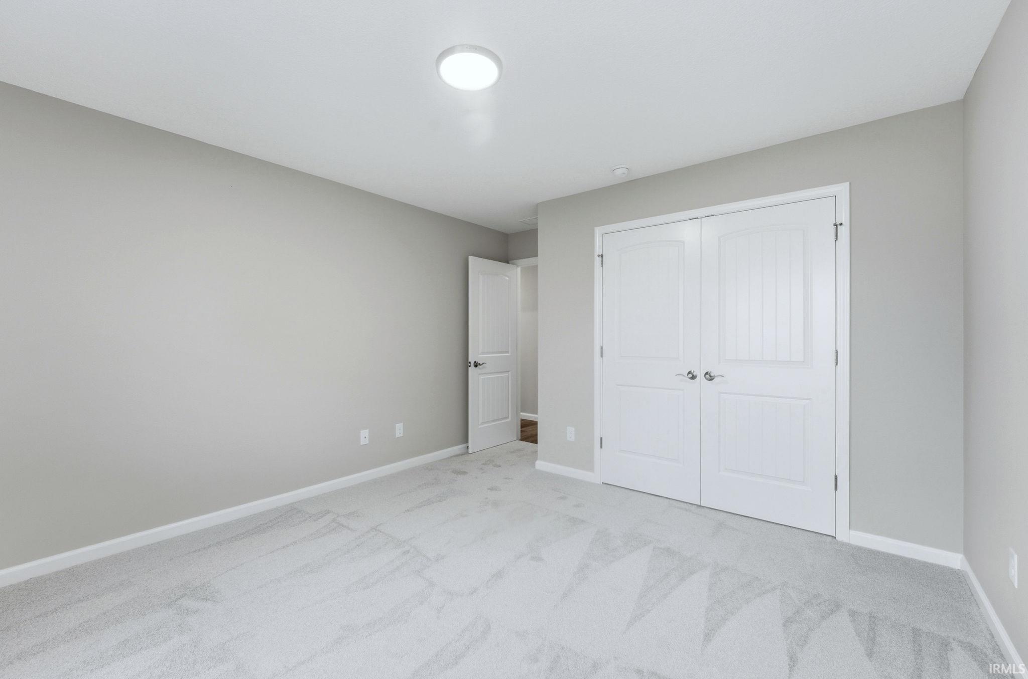 Unfurnished bedroom featuring carpet flooring and a closet