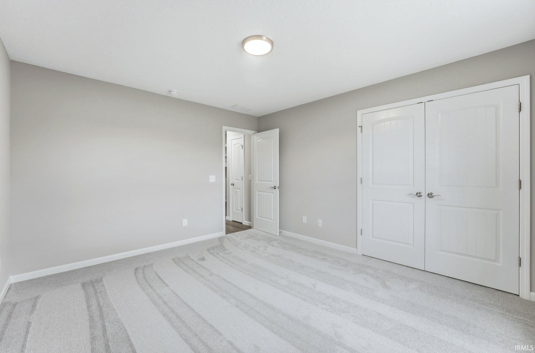 Unfurnished bedroom featuring carpet and a closet