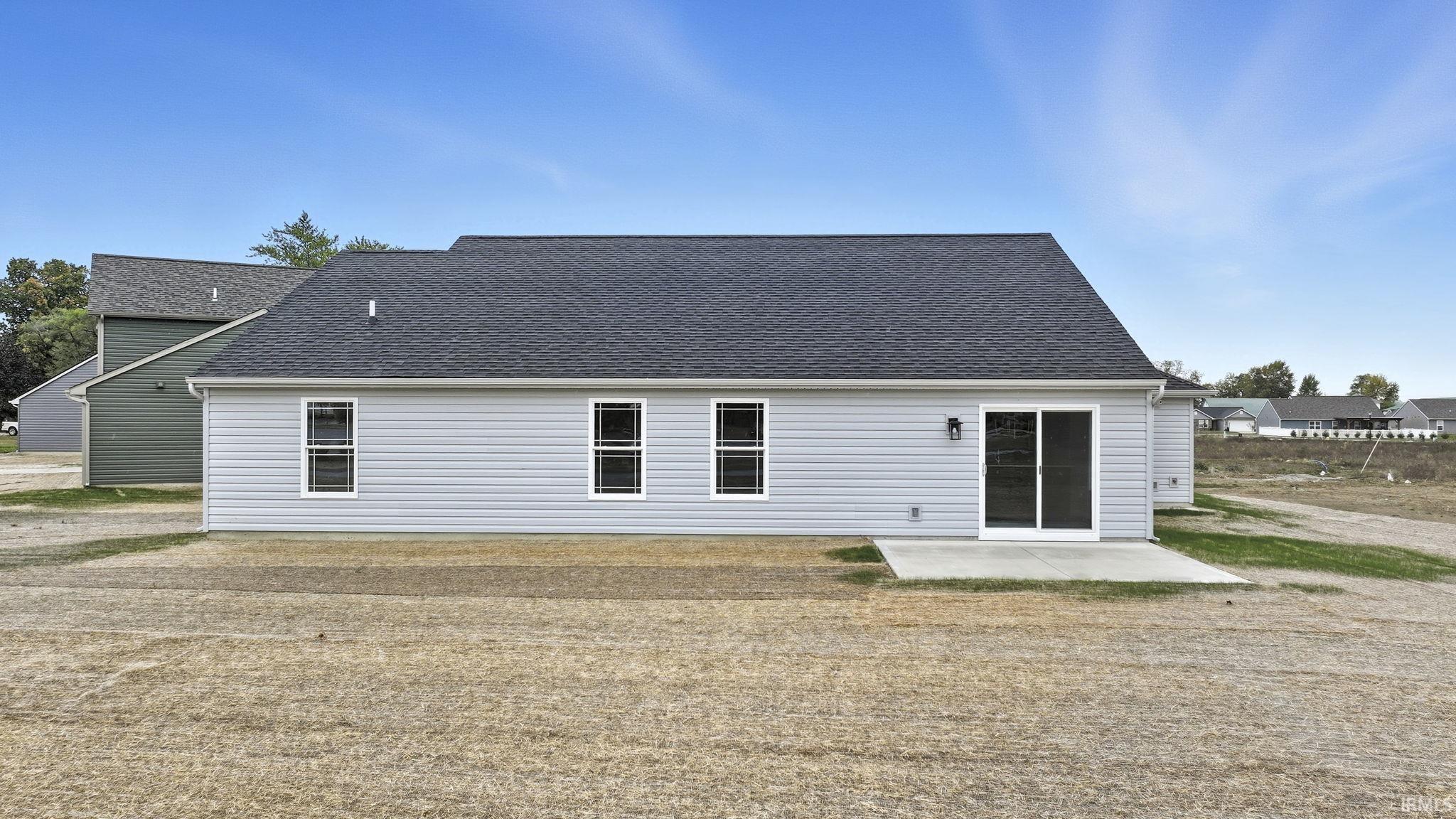 Back of house with a patio and roof with shingles