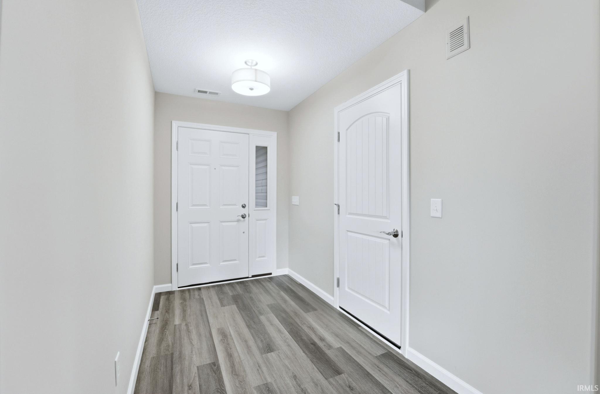 Doorway with baseboards and wood finished floors