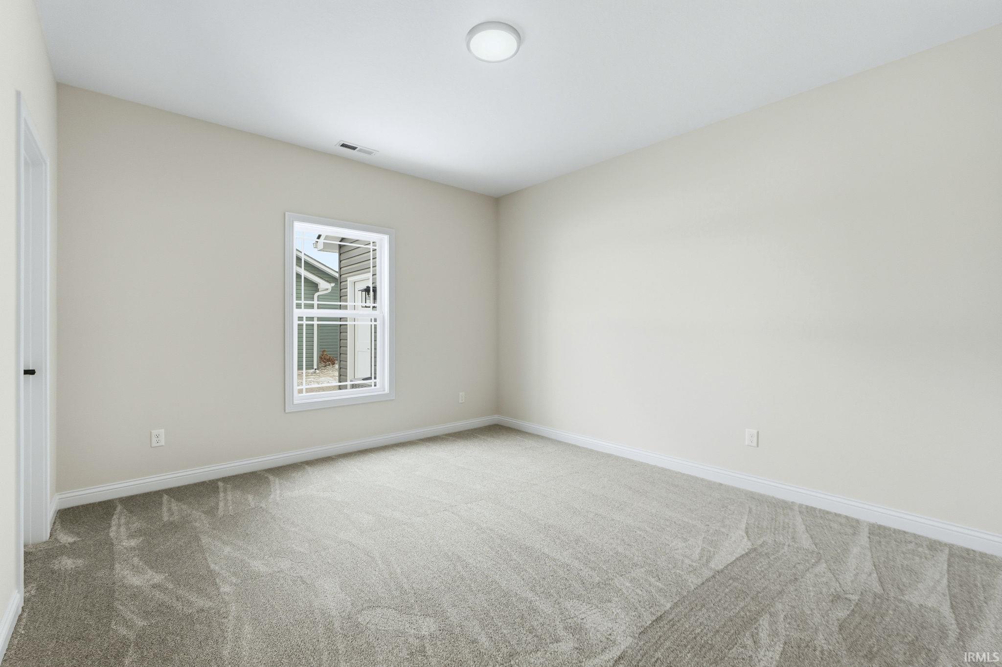 Spare room with light carpet and baseboards