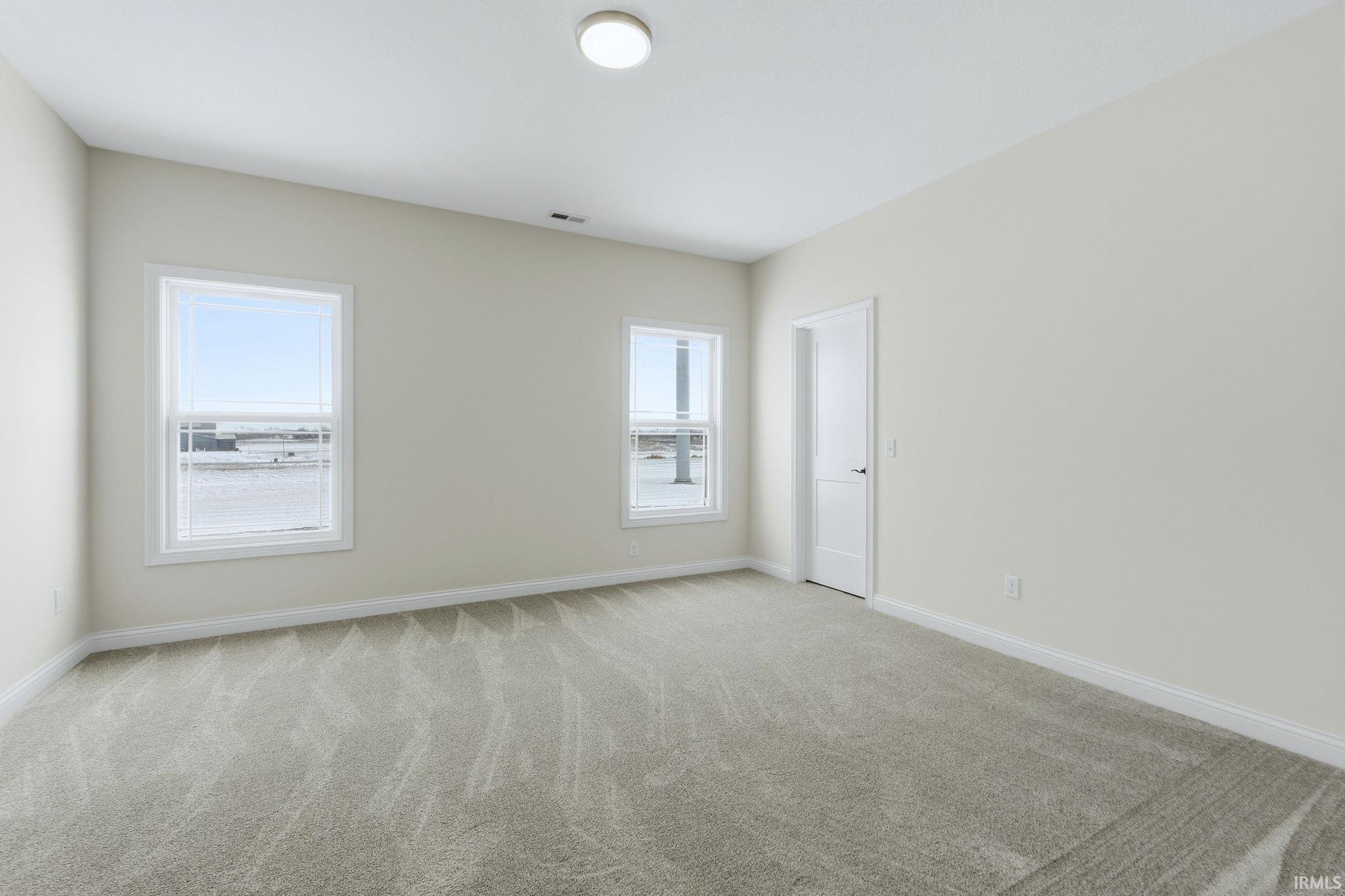Carpeted spare room with baseboards