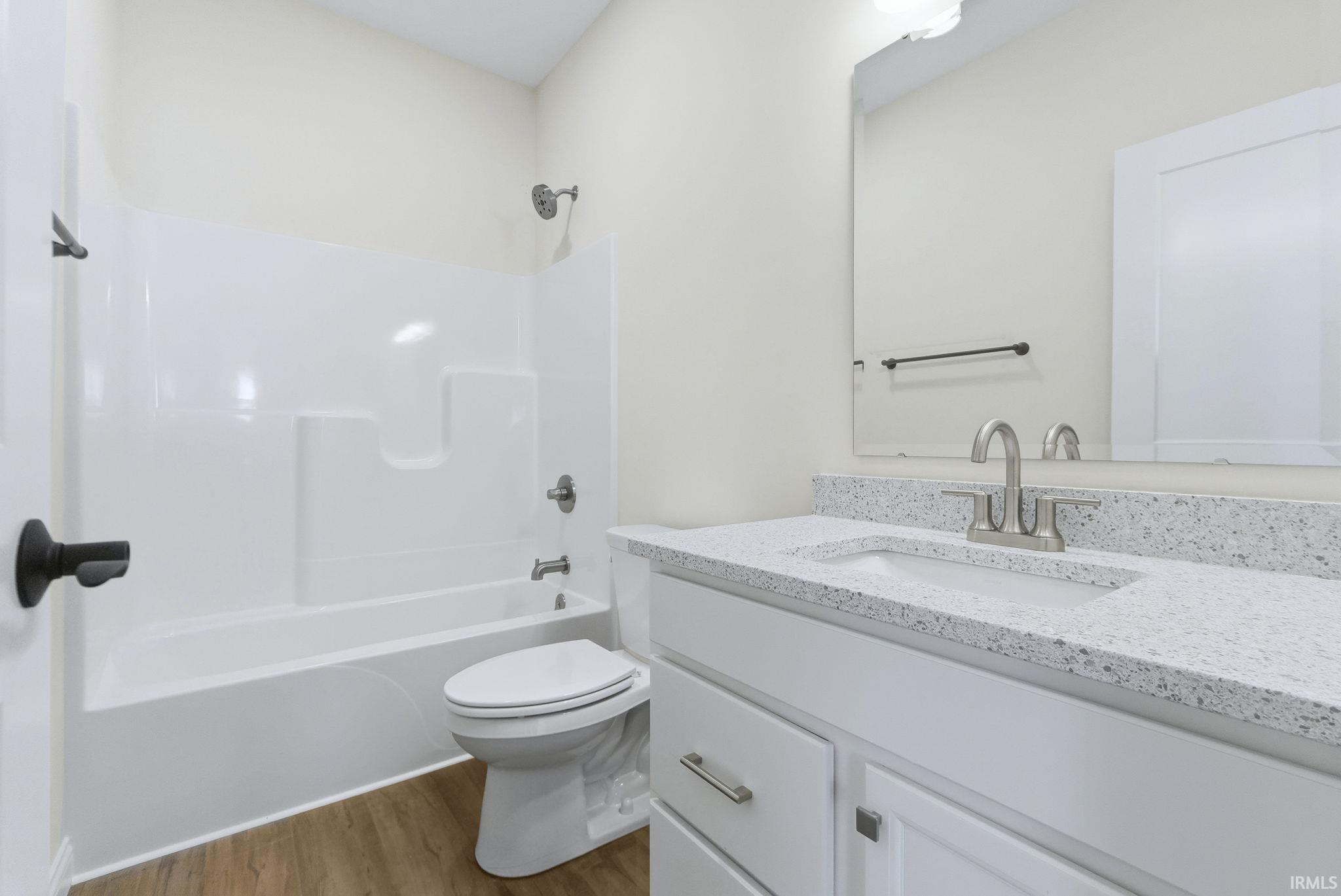 Full bath with vanity, bathing tub / shower combination, and light wood finished floors