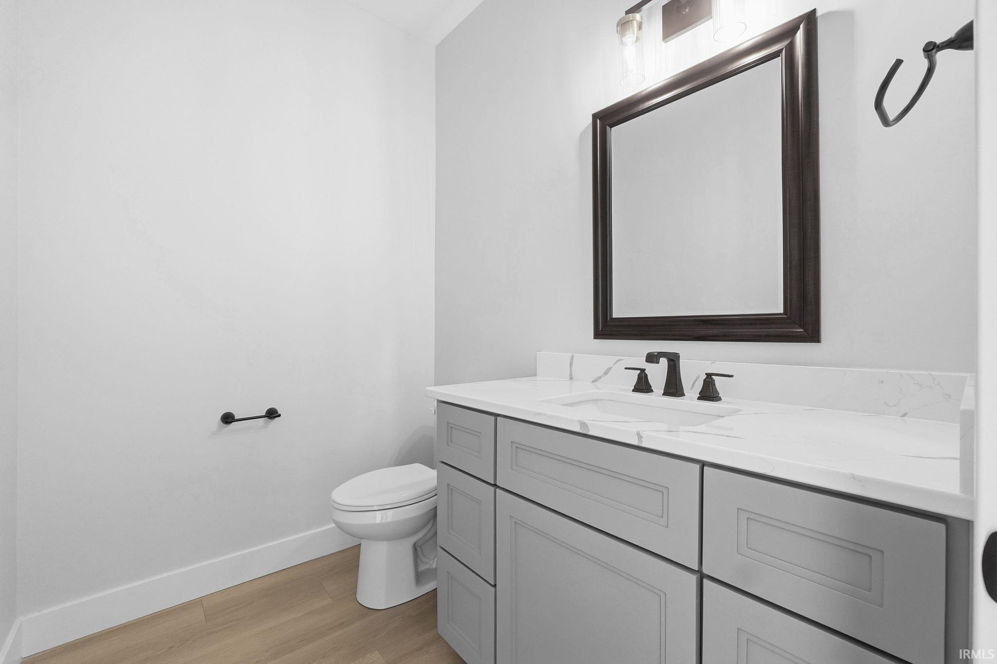 Half bathroom featuring vanity and light wood finished floors