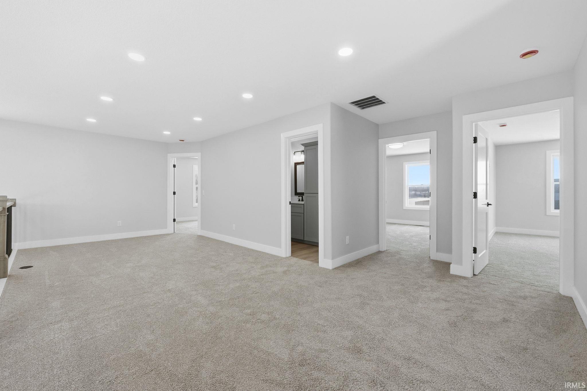 Unfurnished living room featuring light carpet and recessed lighting